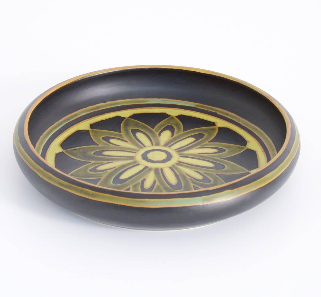 This Art Deco bowl in matte enameled earthenware is decorated with a polychrome floral rozette.
It was designed by Charles Catteau.
This nice bowl in mint condition can be dated in 1925. It is marked.

Bibliography: Pairon, M., Art Deco