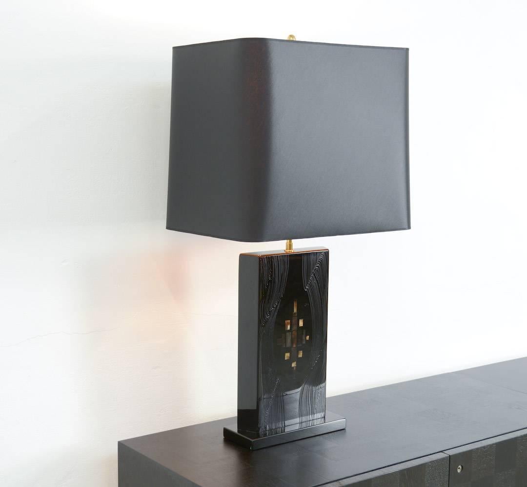 This exclusive table lamp of the 1970s was designed by the Belgian artist Fernand Dresse.
The base is made of black colored resin with bone inlay. The artist created a geometric design with the rectangular bone pieces in different colors of golden
