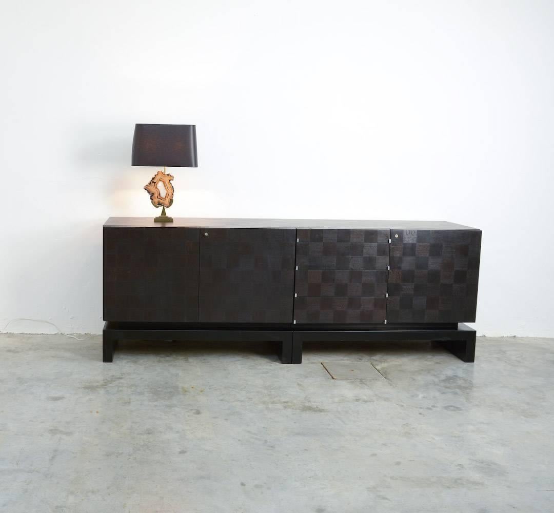 This black ebonized geometric sideboard was made by De Coene in Belgium in the 1970s.
The geometric design is created by the square veneer wood inlay.
This sideboard in in good vintage condition with some small restorations.
It exists of two