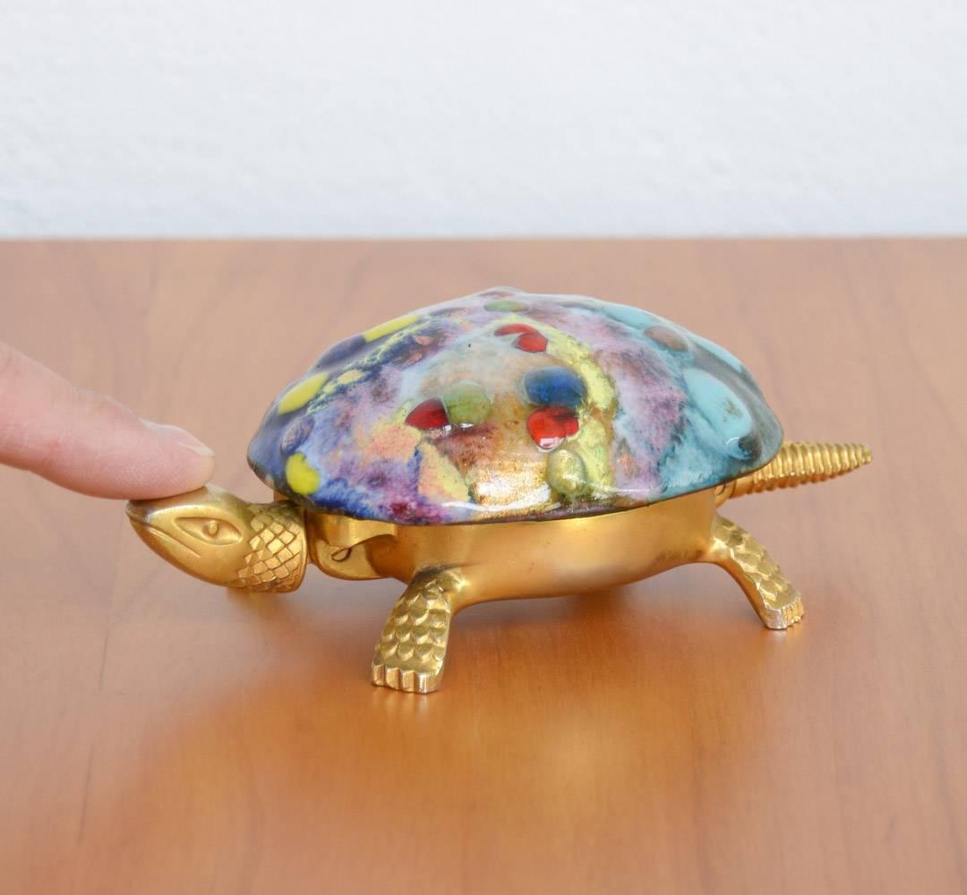 This 1960s office turtle bell is made by BOJ, Eibar, Spain.
The golden metal turtle has a glazed carapace in all different colors.
The bell has to be wind-up, it rings by pushing on the tail.
This nice turtle bell is in good vintage condition.
 
