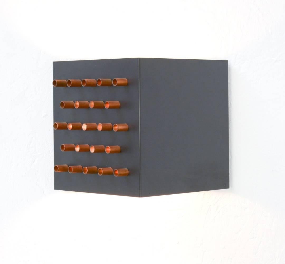 The Clair-Obscur wall lamp is manufactured by RAAK. It can be dated in the 1960s.
The triangular black lacquered base is perforated on one side and finished with copper tubes, this creates a nice light effect.
The top and the bottom of the base