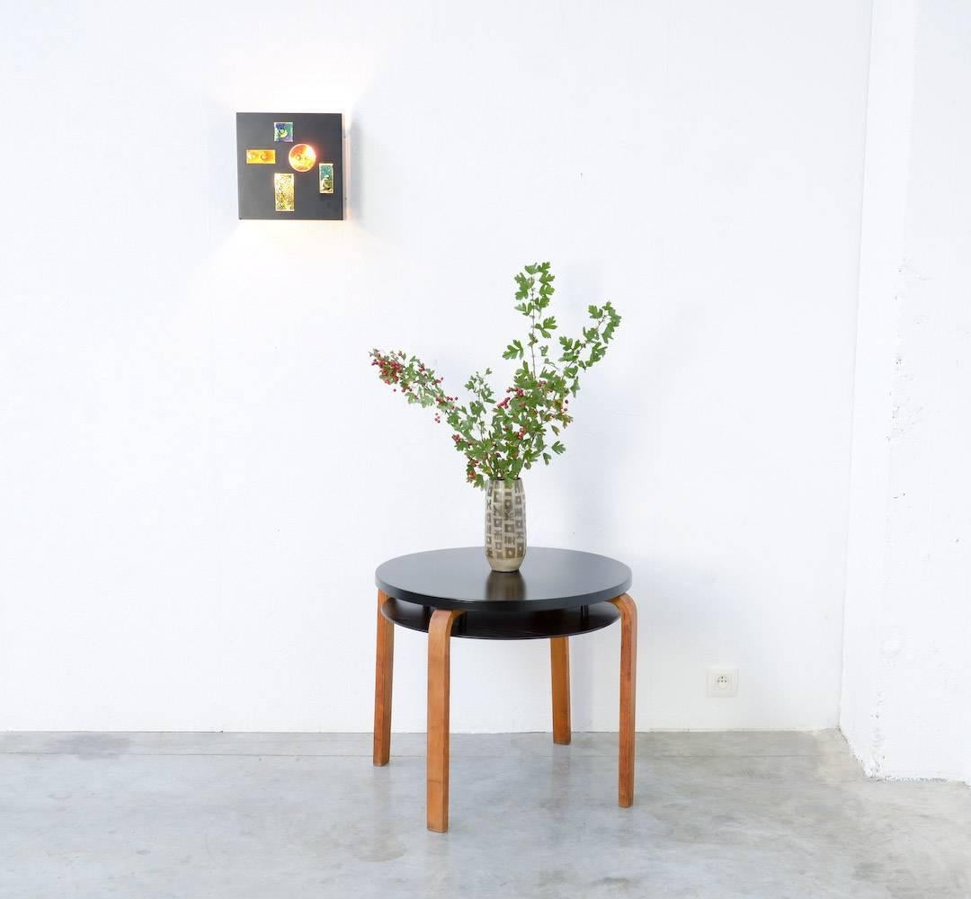This coffee table 70 was designed by Alvar Aalto in 1933 for O.y. Huonekalu – ja Rakennusstyötehdas A.b./ Artek.
The typical L-legs are made of natural bent massive wood.
The birch table top and the plywood shelf are black lacquered.
This very