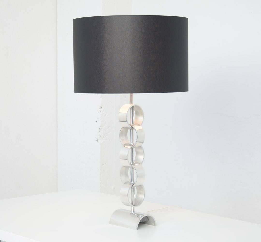 This beautiful table lamp can be dated in the 1970s.
It is a stylish minimalist table lamp made of 5 chromium-plated rings, chained together.
This lamp is in perfect condition, it is rewired and it has a new shade.