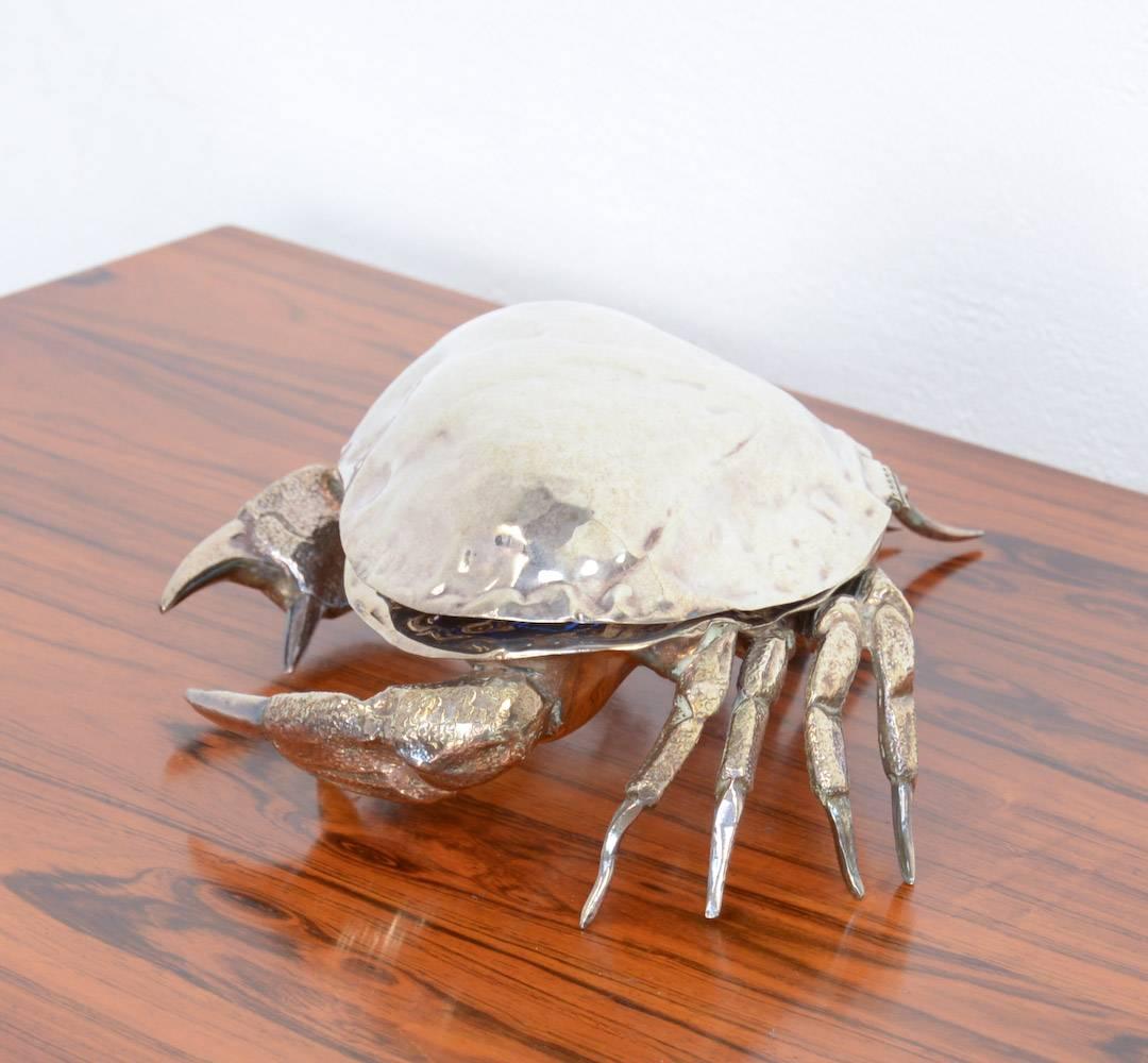 This large silver plate crab is a caviar server. Once opened you will see the cobalt-blue glass bowl for the caviar. As caviar has a unique flavour, it needs to be served on ice.
Around the bowl you have enough space for ice to ensure the caviar is