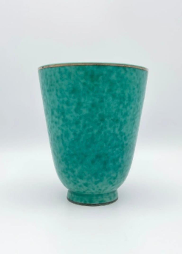 Wilhelm Kåge (1889-1960) è una figura centrale nella storia del design ceramico svedese del XX secolo. Ampiamente considerato come un pioniere del modernismo svedese, Kåge ha svolto un ruolo cruciale nel plasmare l'identità estetica della nazione
