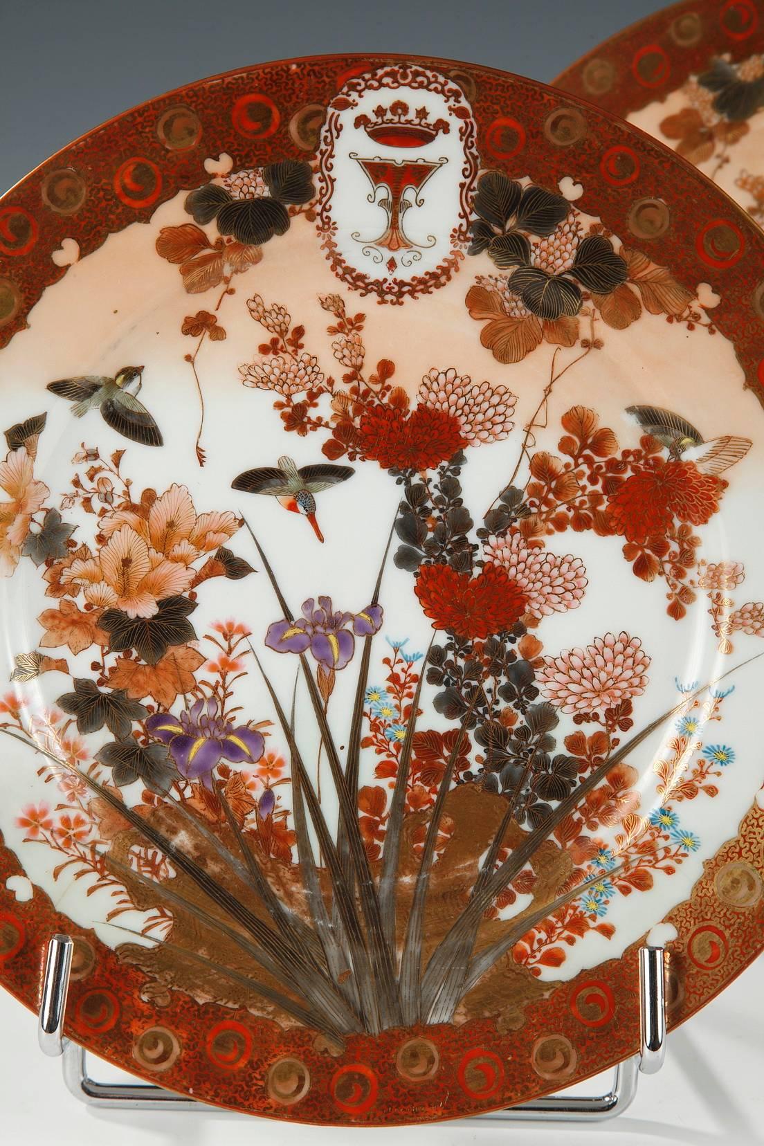 Lovely part of Imari porcelain table service, made for the European market in Japan. 
Iris, Japanese chrysanthemum, cap’s daisies, vine leaves, and small birds, create a rich purple and pink shades floral décor, all of which is circled by a gold