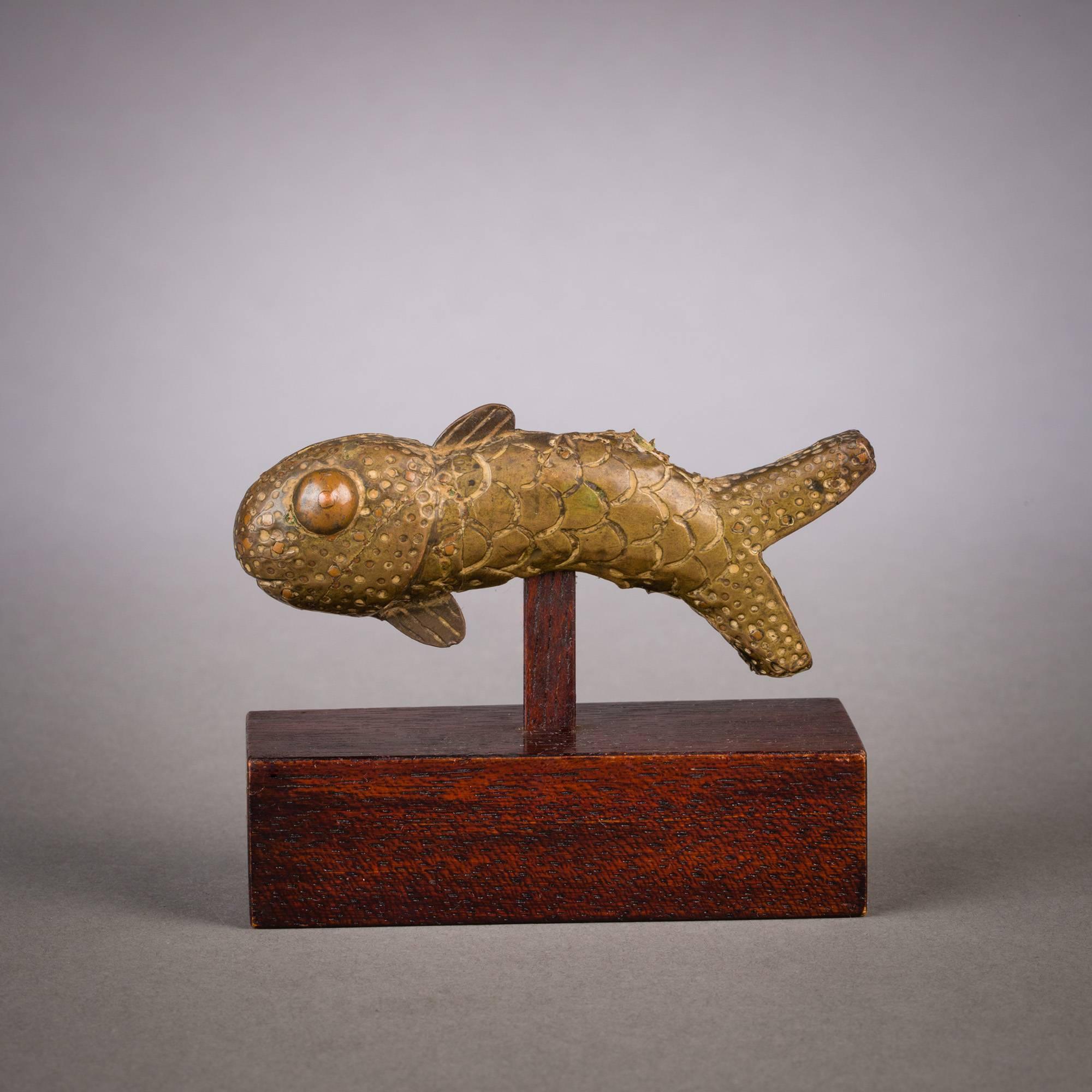 This small piscine figure once served as a finial ornament to a larger work. Close examination reveals a fine range of textural details and patterns that vividly describe the surface. A subtle sinuosity runs through the body, suggesting an almost