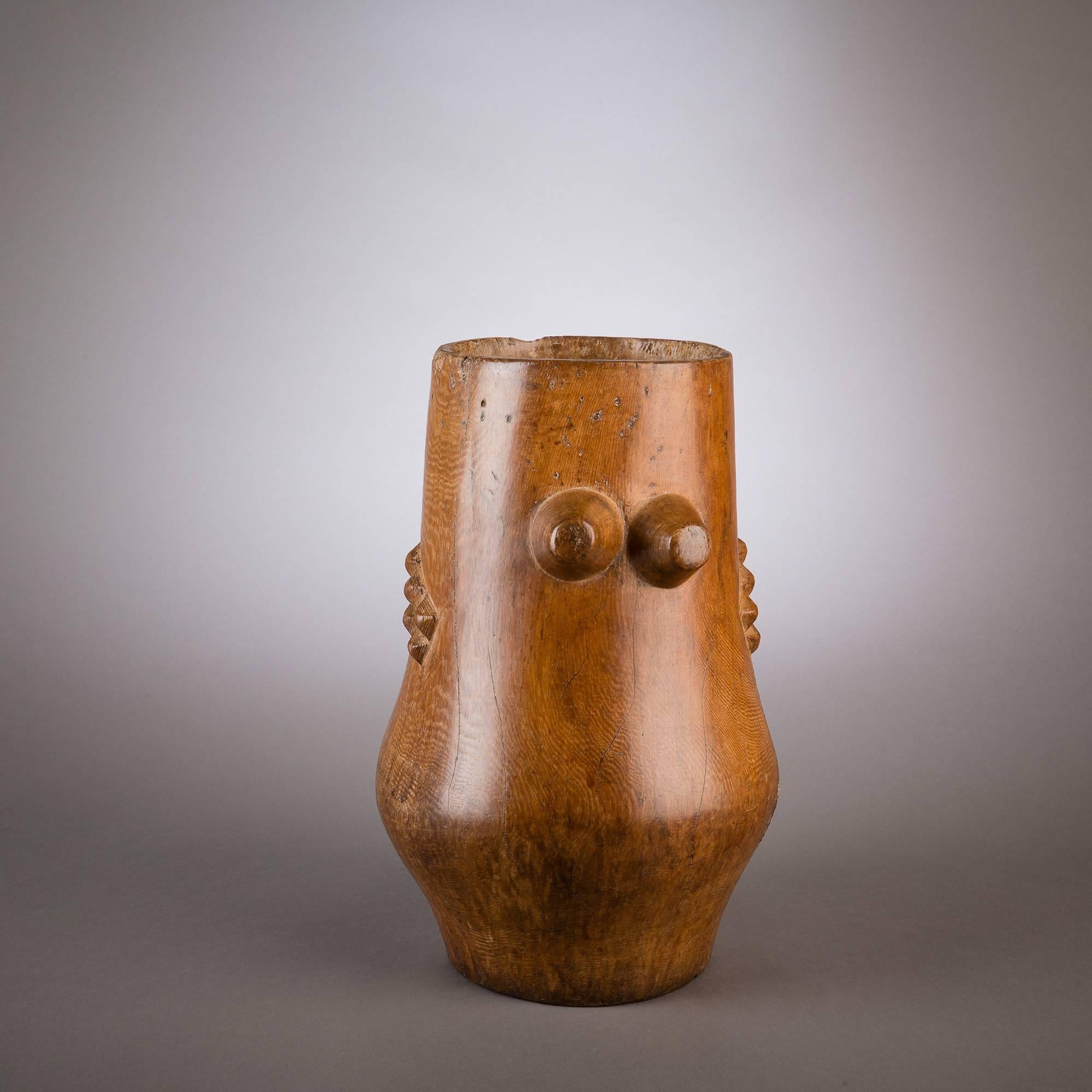 Handsome milk pails such as this example were made by highly skilled Zulu carvers and were commissioned by the heads of homesteads. This beautiful pail contains clear references to the female form. On opposing sides of the vessel are double