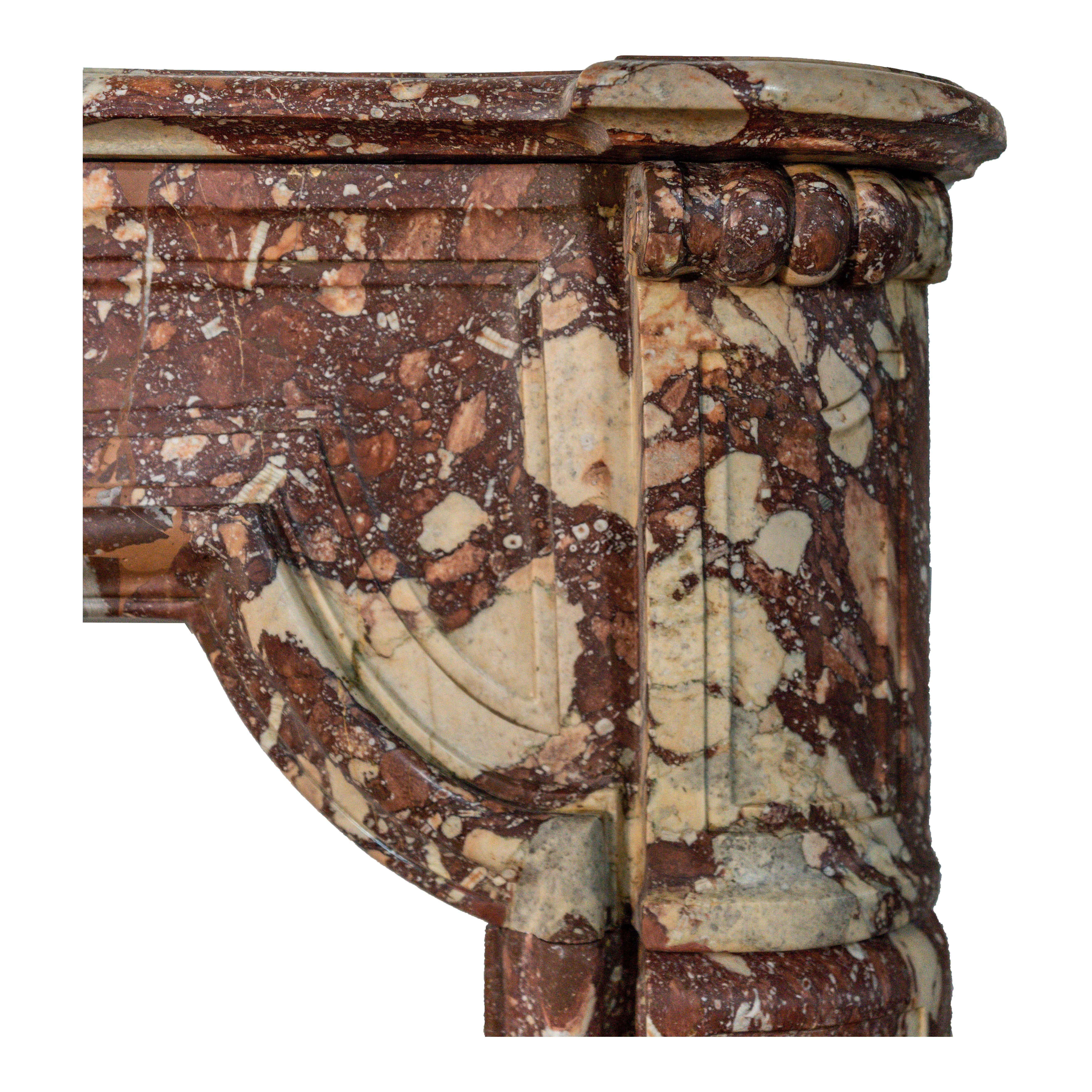 This exquisite 19th-Century French Louis XV fireplace mantel is masterfully carved from richly veined rouge marble, embodying the opulence and artistry of the Rococo period. The serpentine lines and detailed floral and foliate carvings are hallmarks