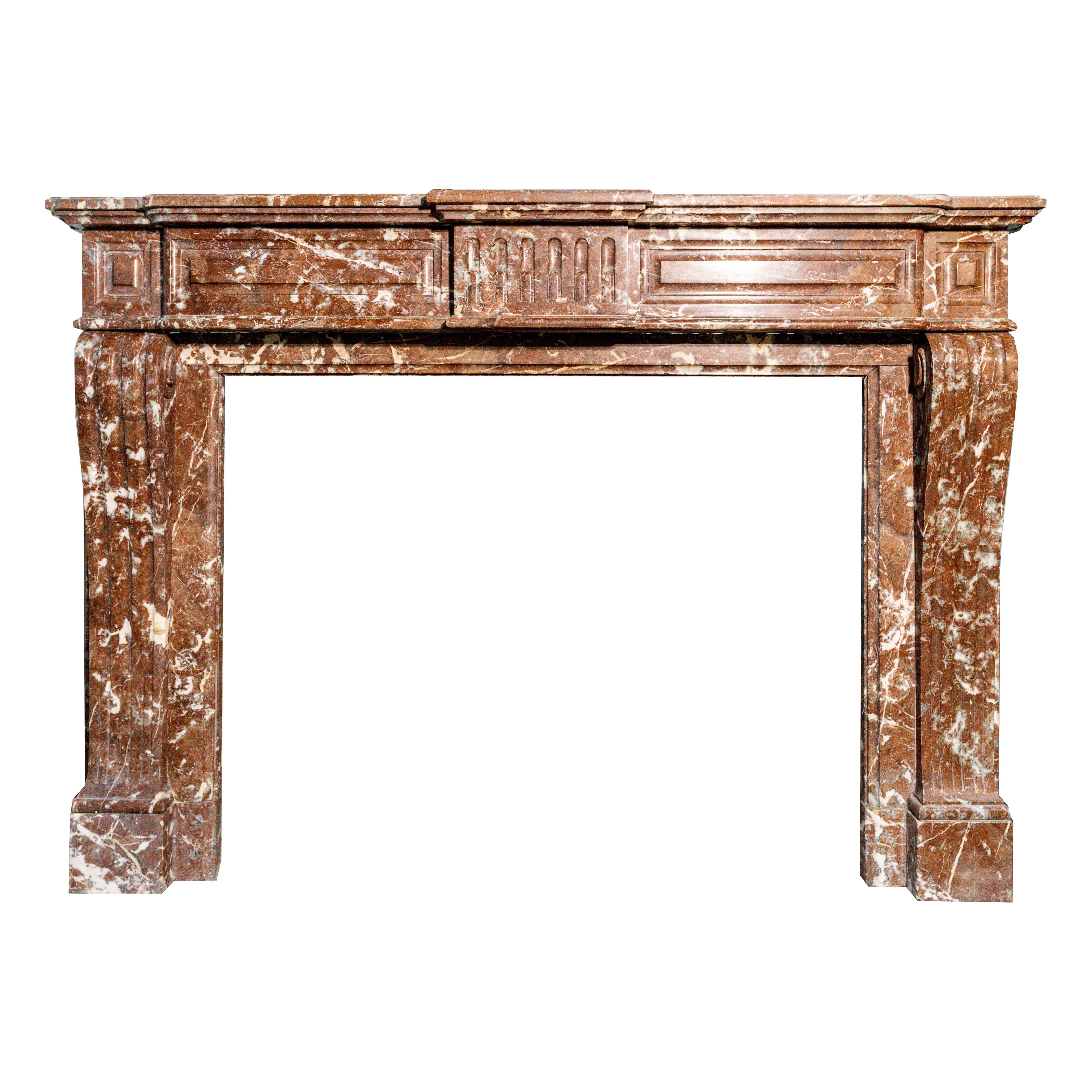 A refined and stately French Louis XVI period fireplace mantel, crafted circa 1780–1790, in richly variegated Rouge Royal marble. This neoclassical masterpiece features a linear architectural form with strong symmetry, fluted pilasters, and a