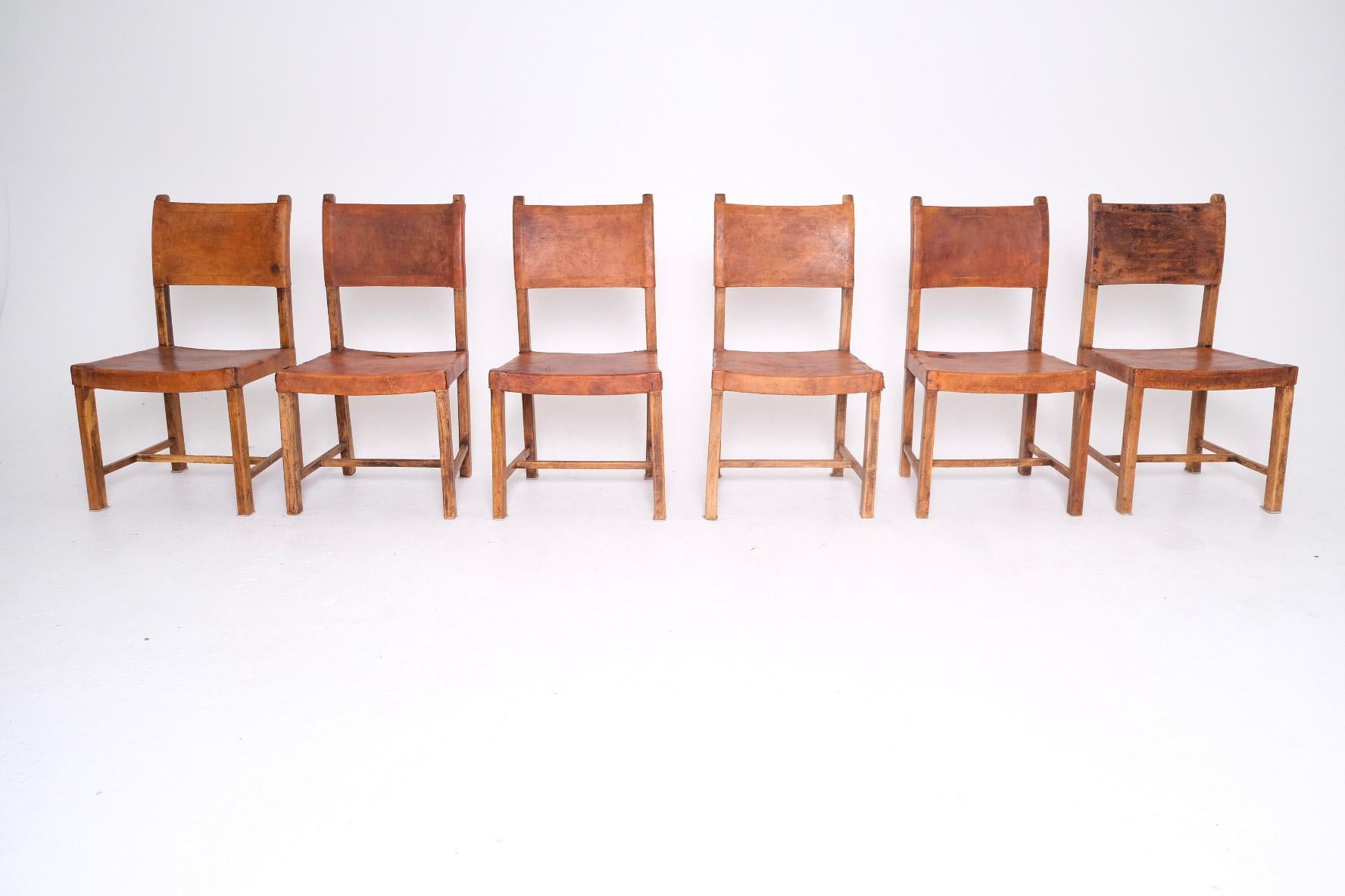 Un ensemble exceptionnellement rare et riche en caractère de 6 chaises de salle à manger de monastère espagnol, datant du 18ème siècle. Fabriquées à la main en bois massif et recouvertes de cuir tanné végétal original, ces chaises sont imprégnées de