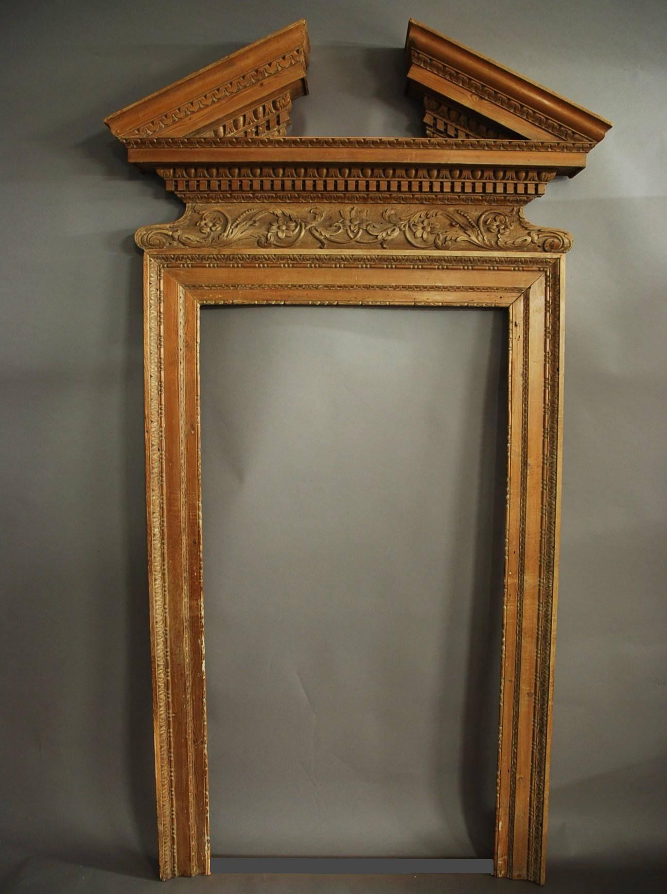 A large and impressive pair of mid-18th century pine door surrounds (or frames) with broken pediment in the Classical design.

These surrounds consist of a carved broken pediment with carved designs including egg and dart decoration.

This leads