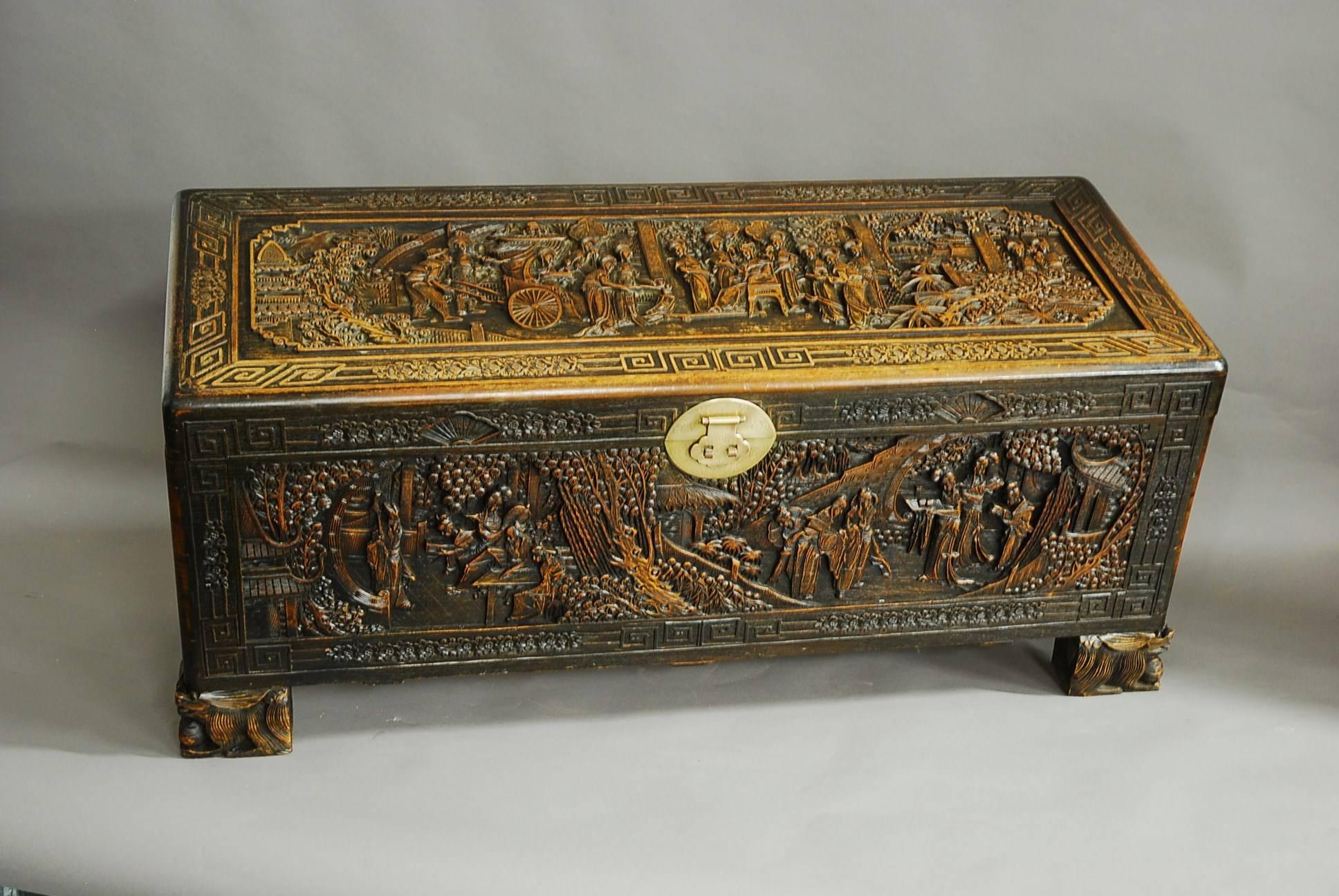 A superb mid-20th century large profusely and deep carved Chinese camphor wood freestanding chest.

The chest consists of a superbly carved top of a traditional Oriental scene with a border of carved geometric and floral decoration with original
