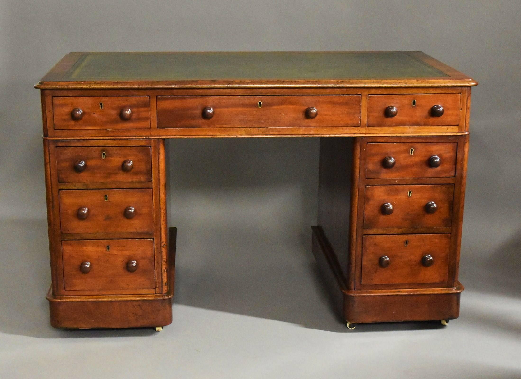 A late 19th century mahogany pedestal desk of small proportions.

This desk consists of an inset green leather tooled top surrounded by a cross banded moulded mahogany edge.

To the top of the desk are three drawers with wooden knob handles with