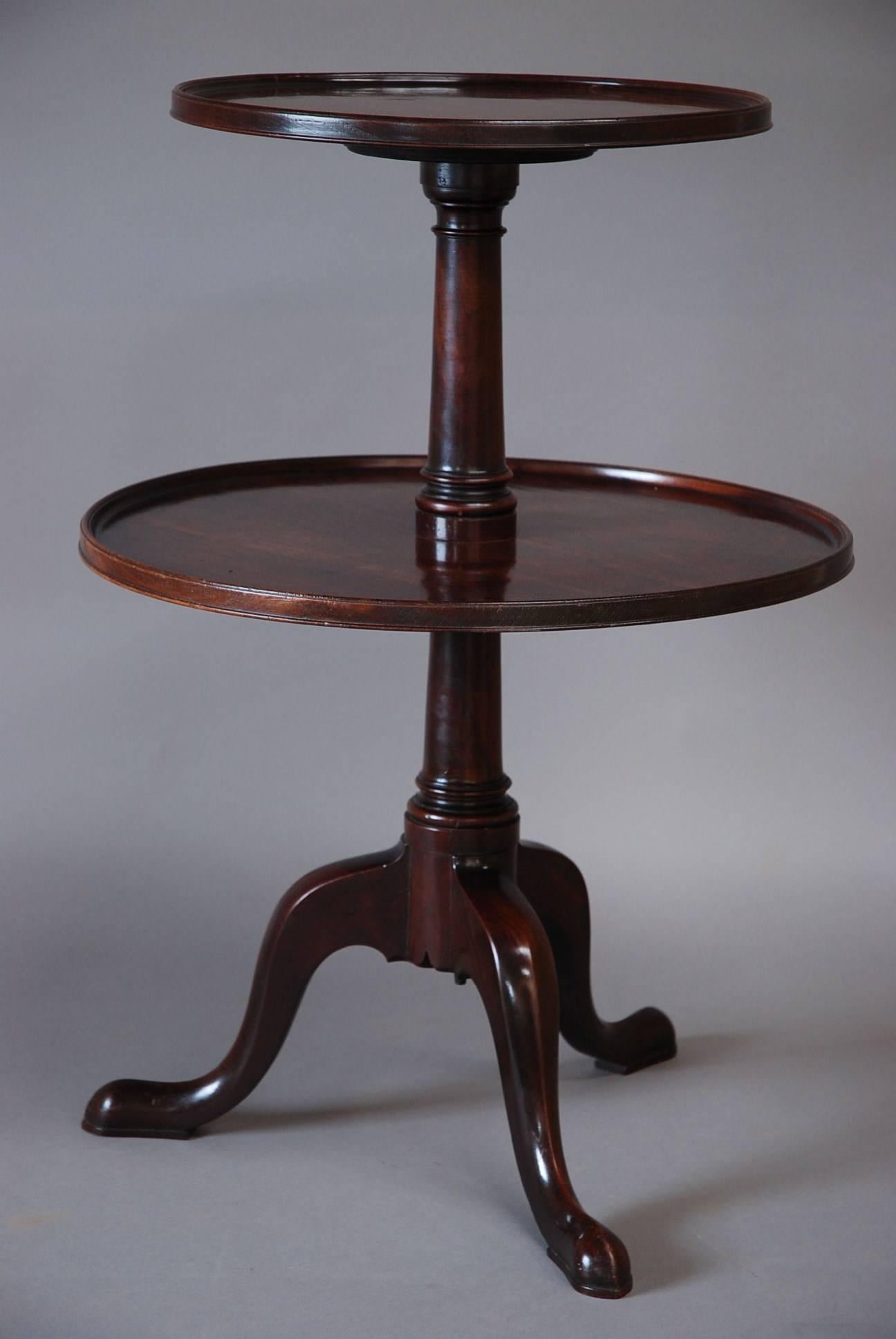 A late 18th century mahogany dumb waiter of good proportions and patina (color).

This item consists of two solid mahogany revolving tiers of dished circular form.

The tiers are supported by a turned gun barrel column and lead down to a
