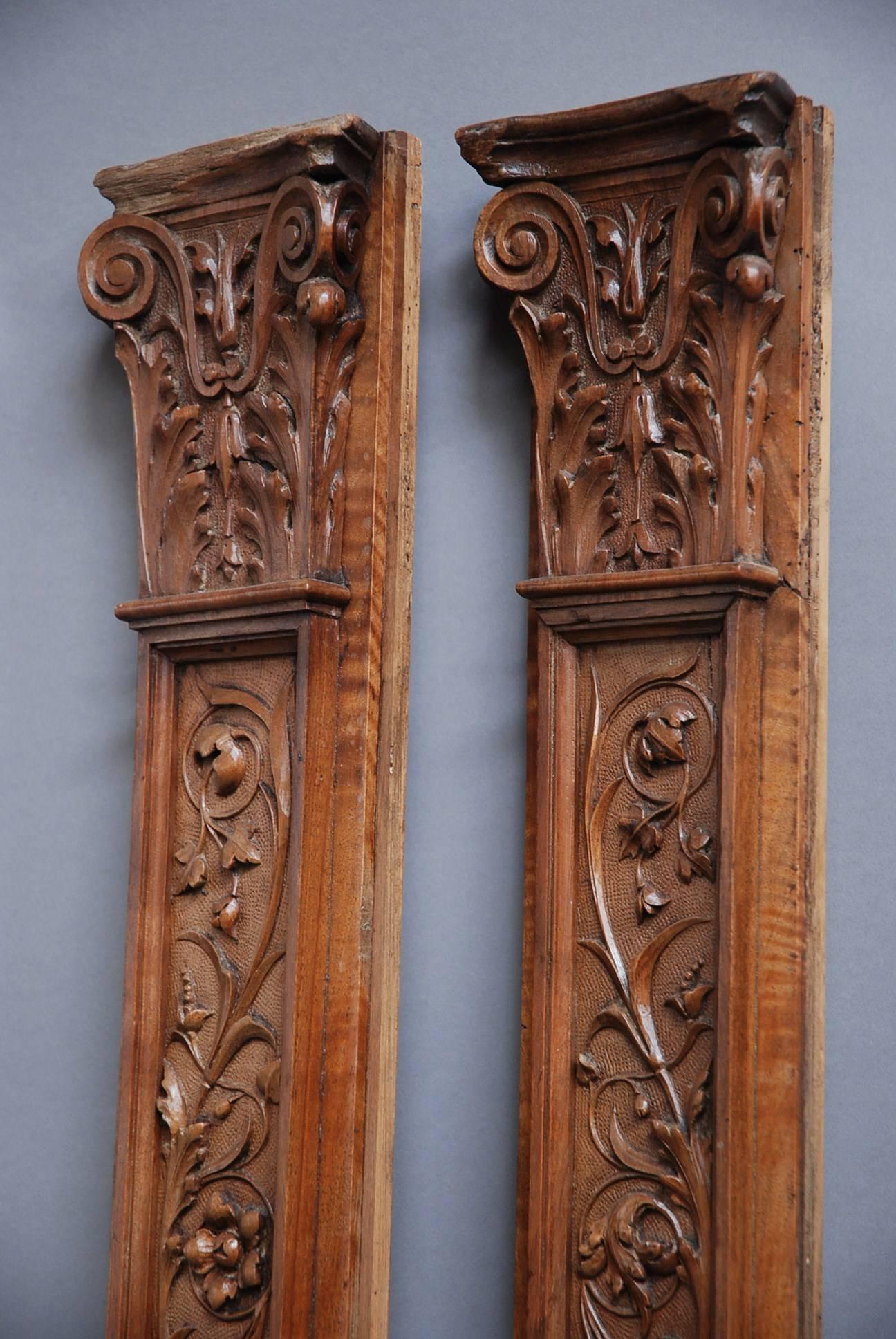 A pair of late 19th century Continental carved walnut pilasters in the Classical form, possibly French or Italian.

The pilasters consist of Corinthian style capitals to the top with carved scrolling floral and foliate designs.

This leads down