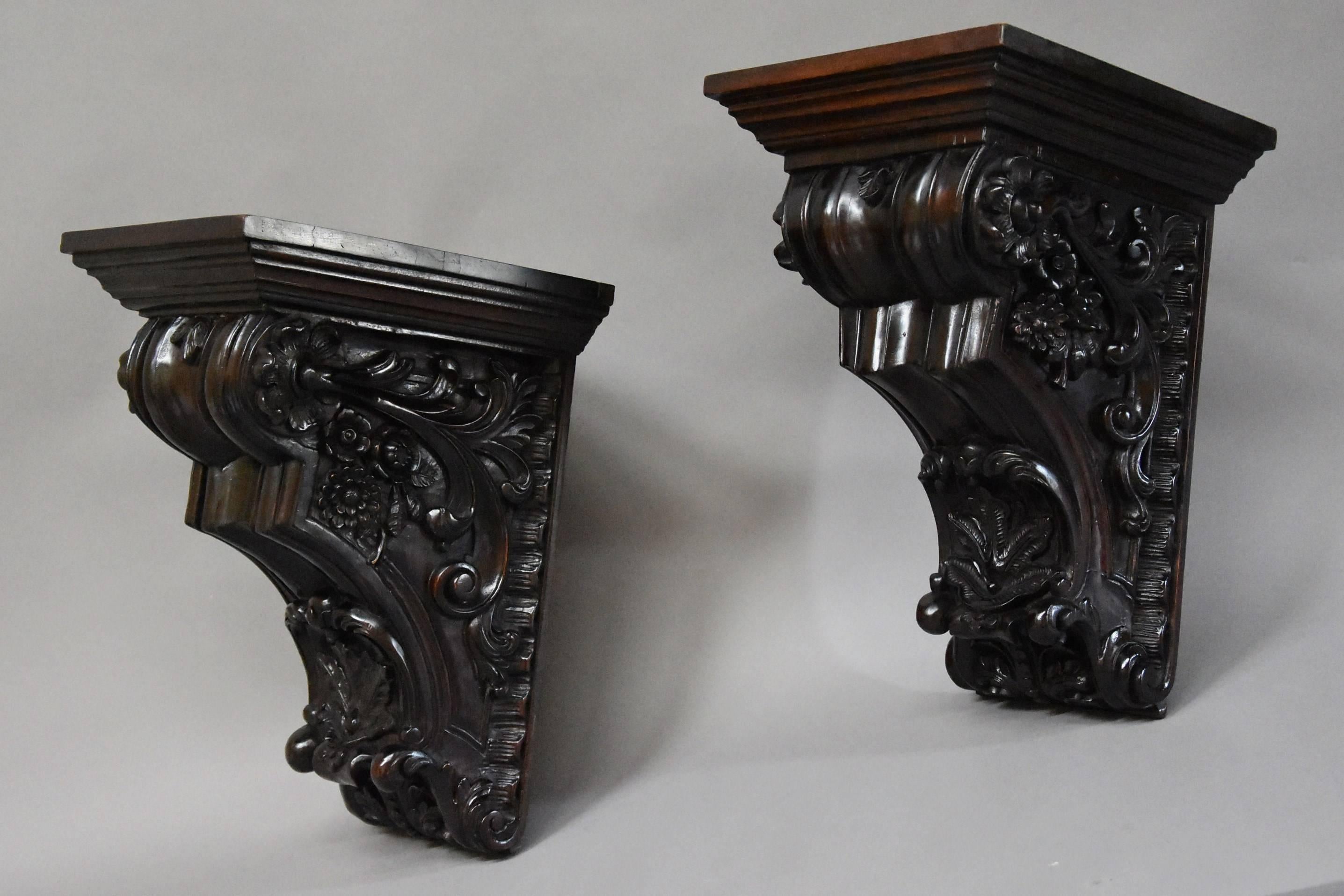 A large pair of late 19th century decorative carved mahogany architectural brackets.

This pair of brackets consist of solid mahogany tops with a moulded edge leading down to a shaped and carved design with superb floral and foliate carved