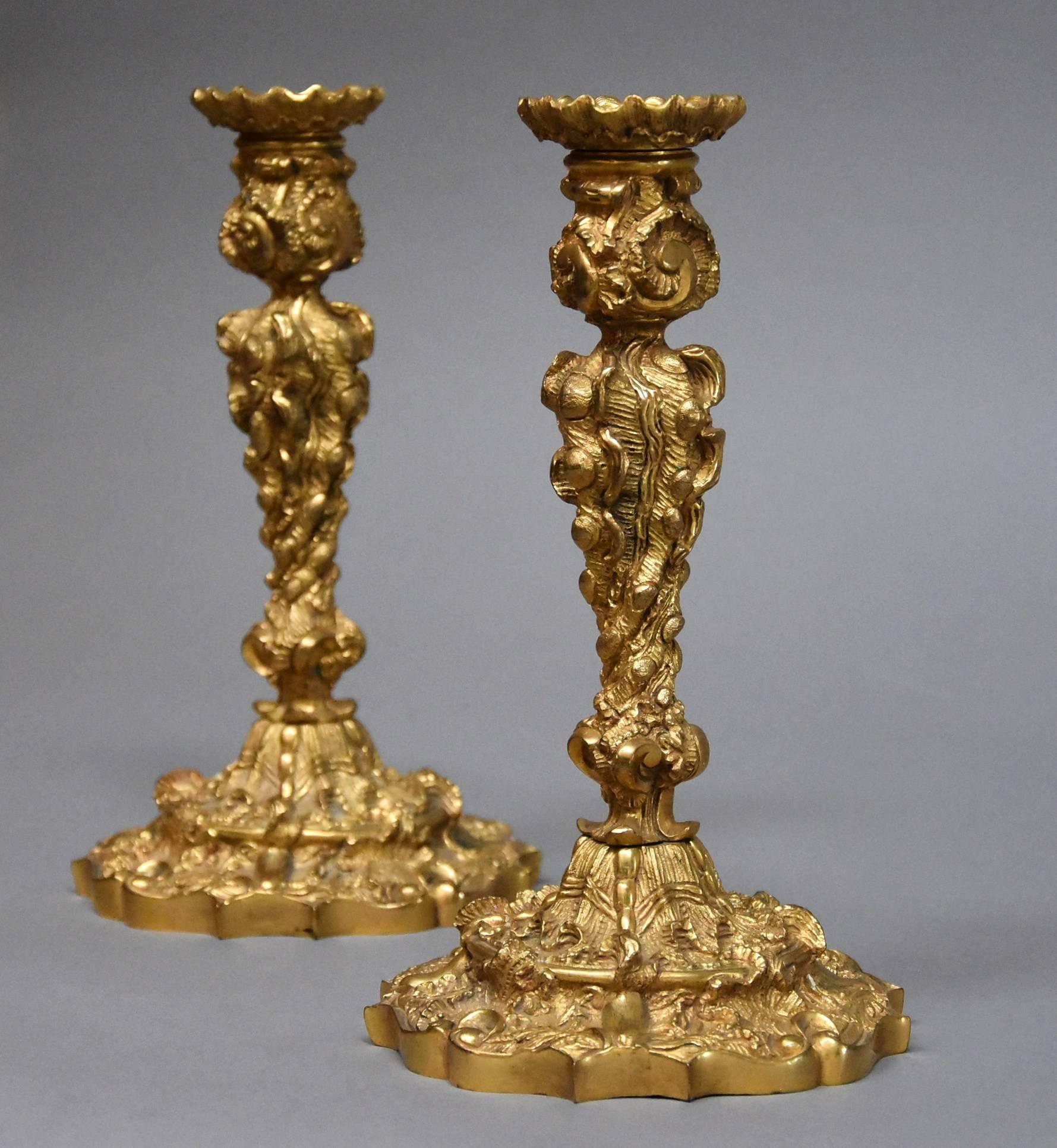 A pair of late 19th century French highly decorative ormolu candlesticks in the Rococo style.

These candlesticks consist of candle holders to the top (these are removable) with scrolling shell decoration.

This leads down to the main body of