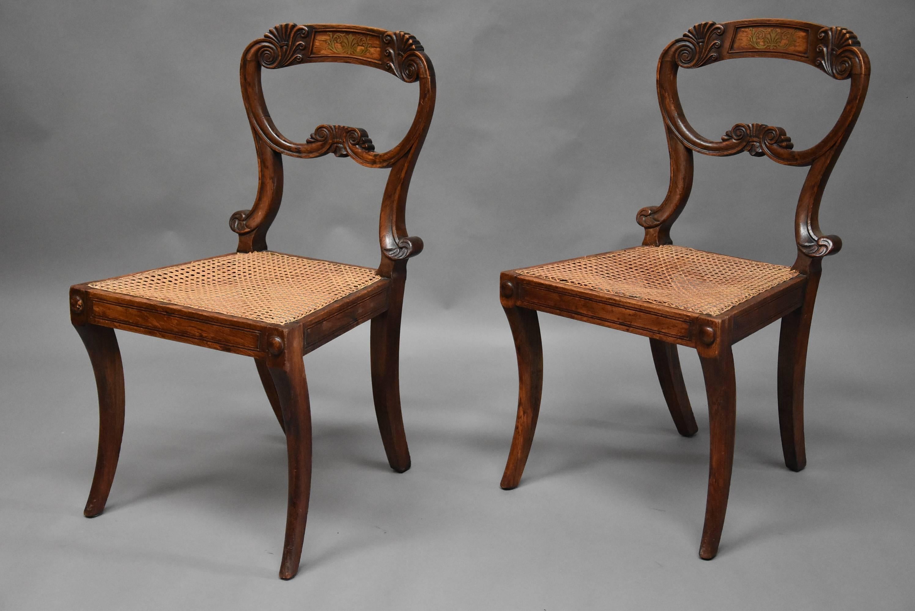 An elegant pair of beech early 19th century simulated rosewood Regency chairs in the manner of Gillows.

This pair of chairs consist of a top rail with inlaid brass decoration to the centre and a carved anthemion style design to either side with