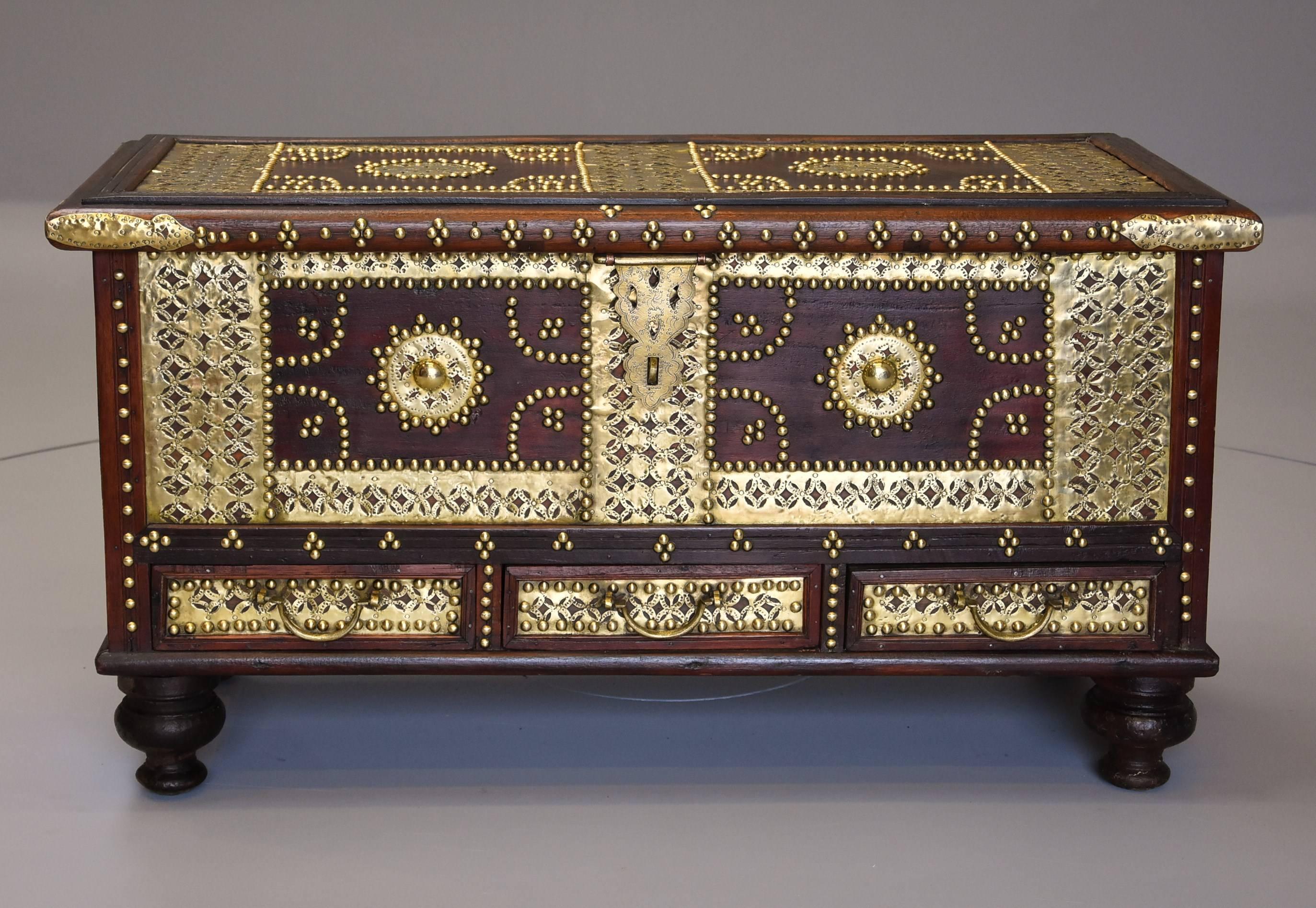 A mid-19th century hardwood highly decorative Zanzibar traders chest decorated with brass stud and metalwork. 

This type of chest would have been used by traders as they travelled to different areas selling spices and silks etc. 

The top is