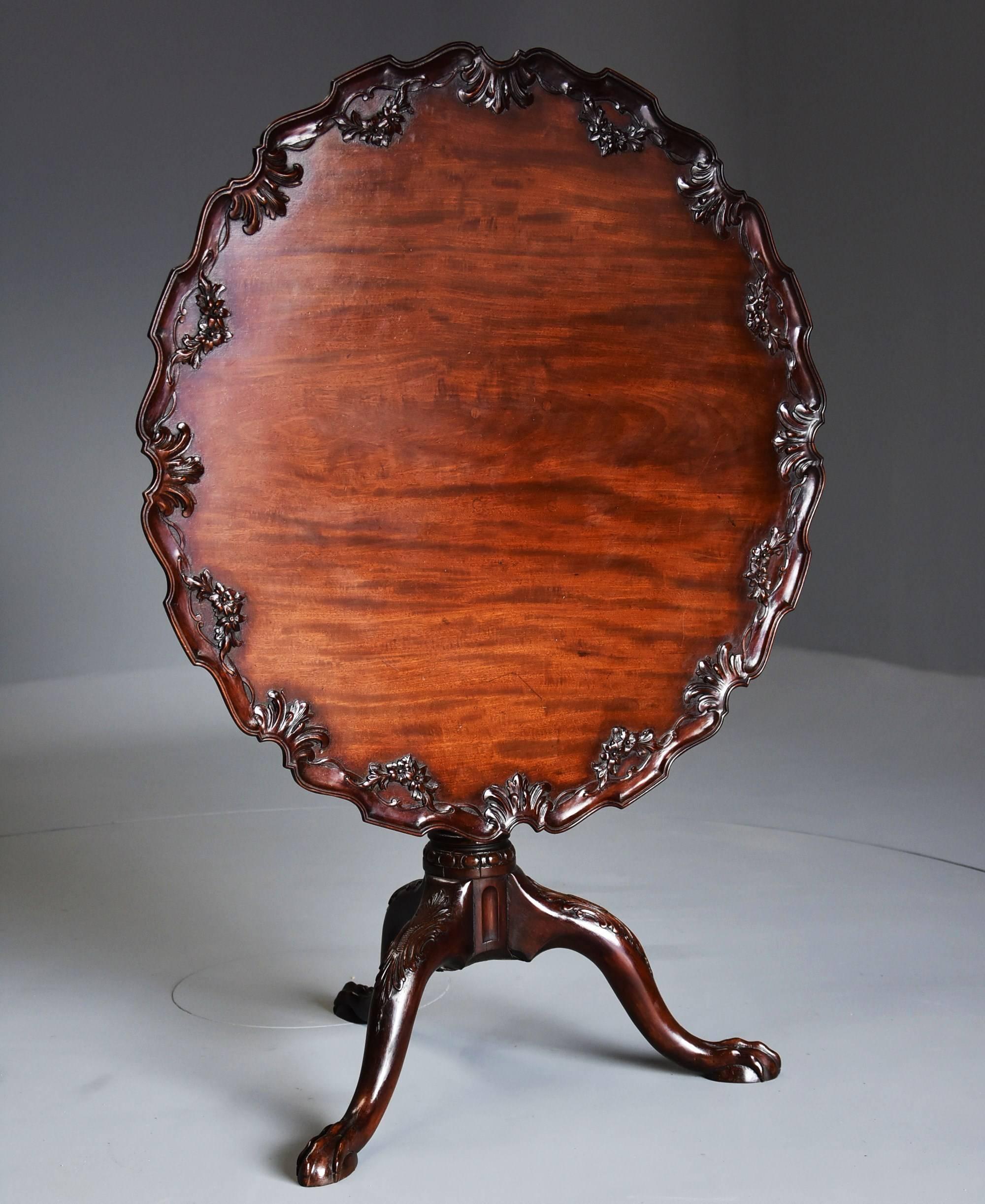 A late 19th century mahogany Chippendale style piecrust tilt-top tea table with tripod base.

This table consists of a mahogany top of superb patina (colour) with applied floral and foliate carved decoration with an applied piecrust decoration to