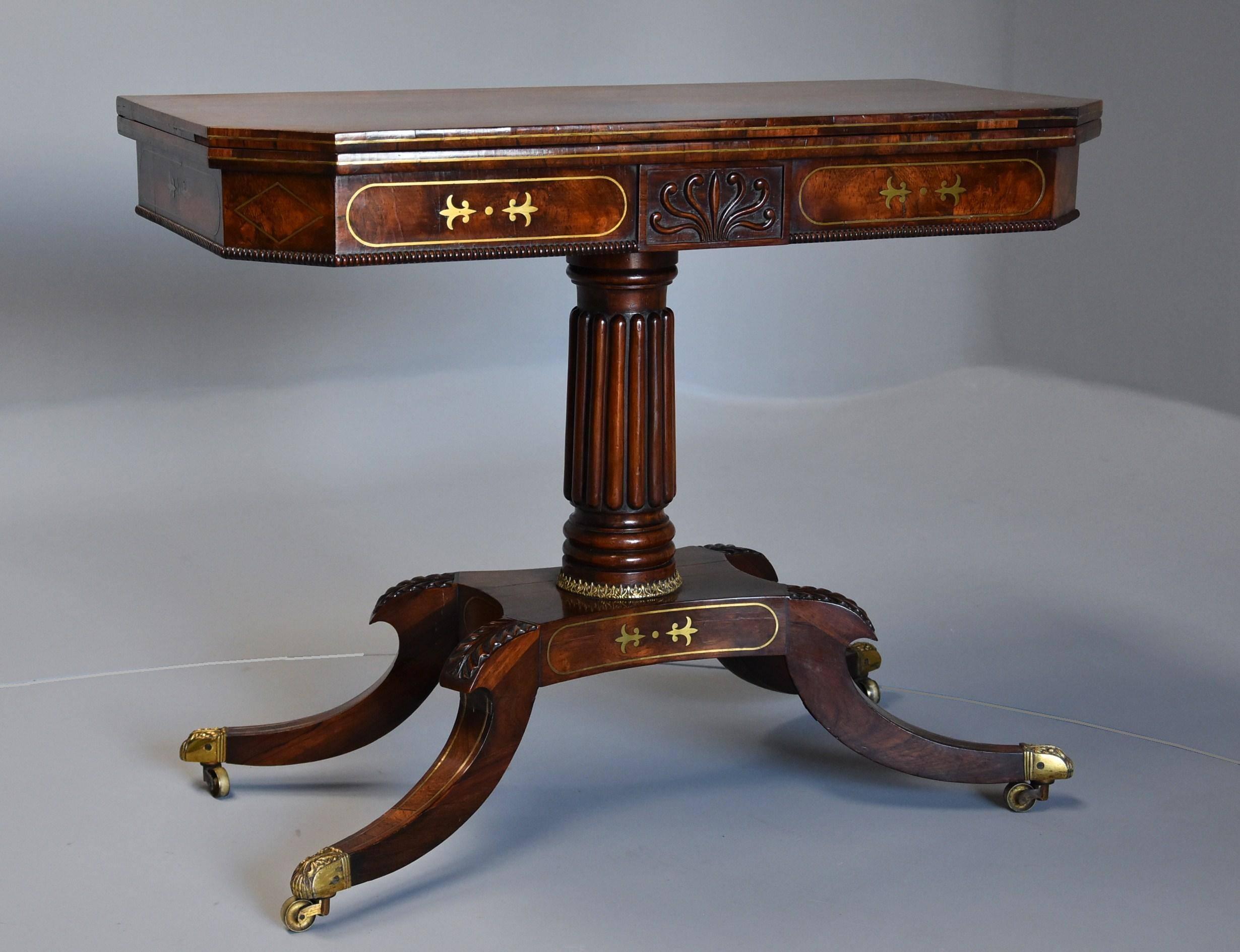 A Regency rosewood card table with brass inlaid decoration of super quality.

This table consists of a superbly figured mirror veneered rosewood top with canted corners with double line brass stringing, the edges also having brass line decoration,