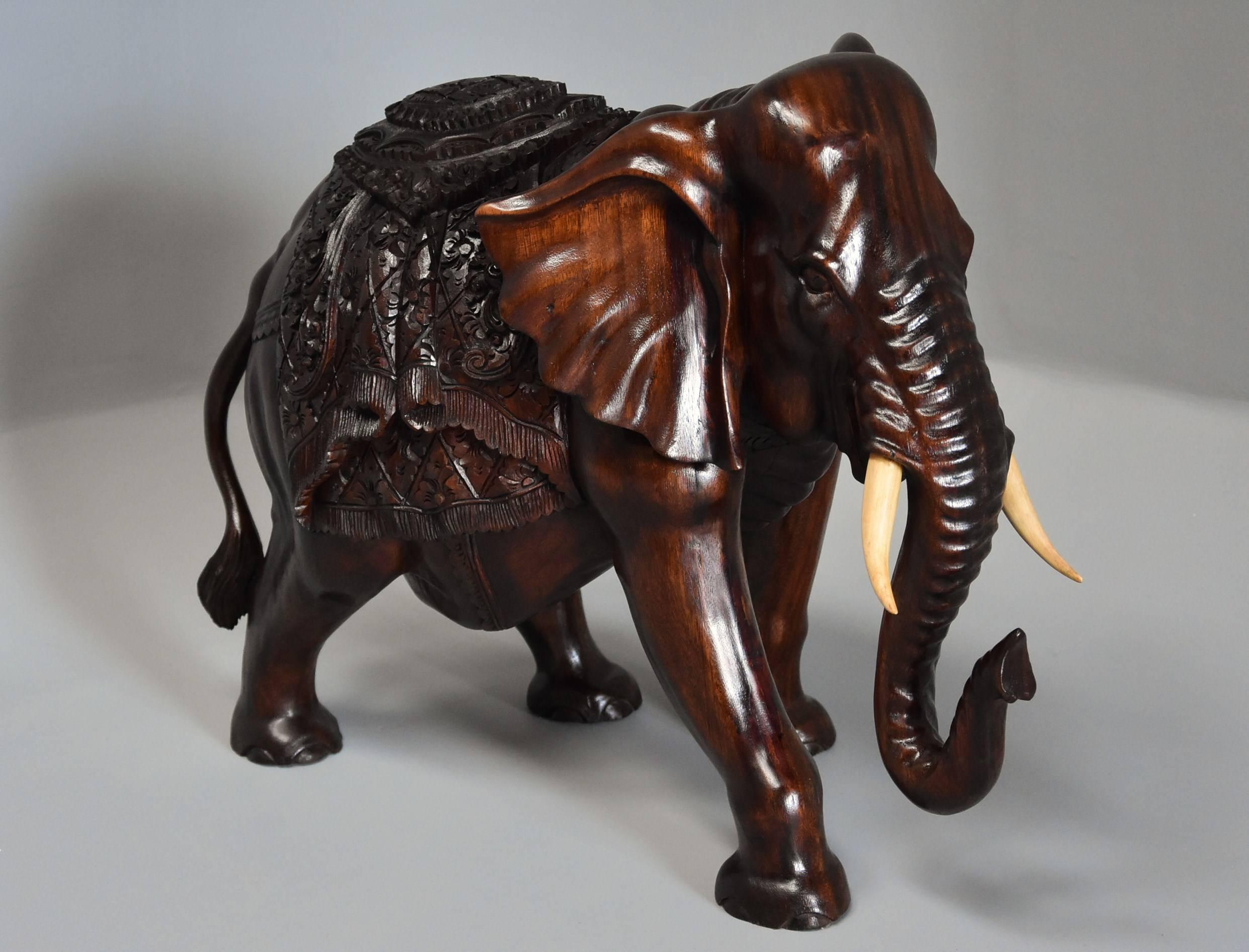 A highly decorative carved hardwood elephant.

This superbly carved elephant figure has wooden tusks and a decorative rug on his back.

This figure is in excellent condition and can go straight into a home.