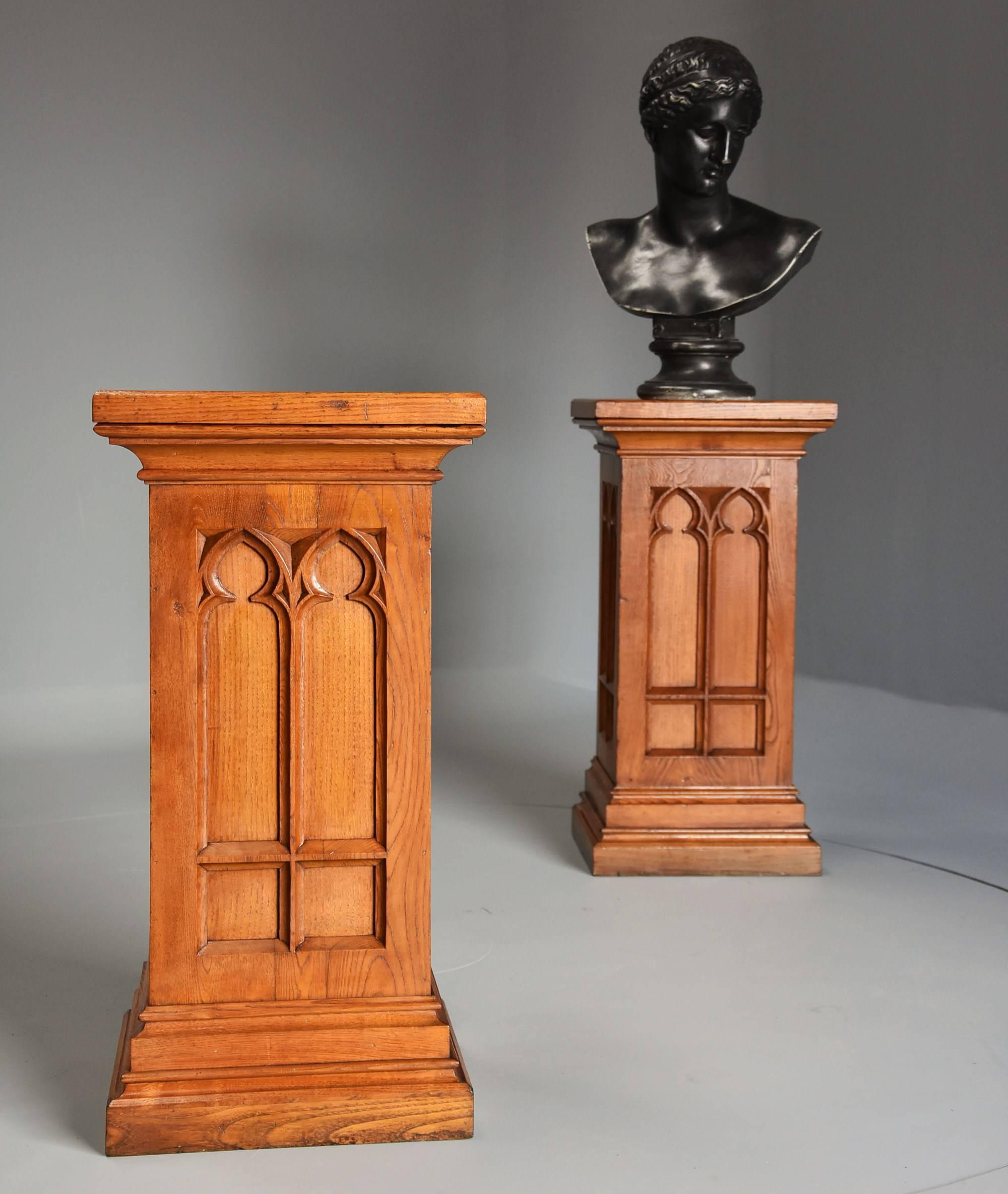 A highly decorative pair of late 19th century ash pedestals in the Gothic style of good patina (color).

These pedestals consist of solid ash tops of square form with a moulded edge leading down to the front and two sides consisting of Gothic