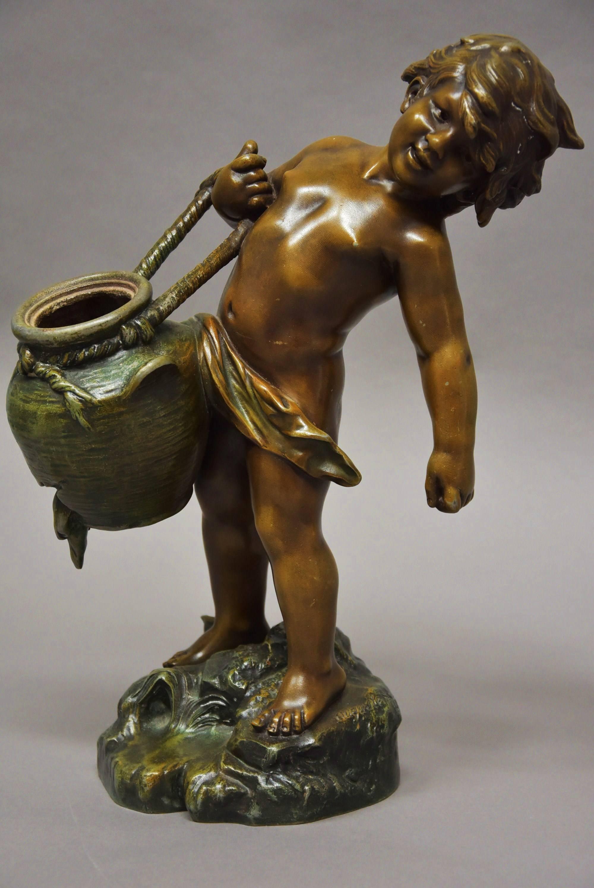A late 19th century French patinated bronzed spelter figure of young male water carrier signed Auguste Moreau (1834-1917).

This figure portrays a young boy struggling to carry a pot of water which is leaking standing on a naturalistic