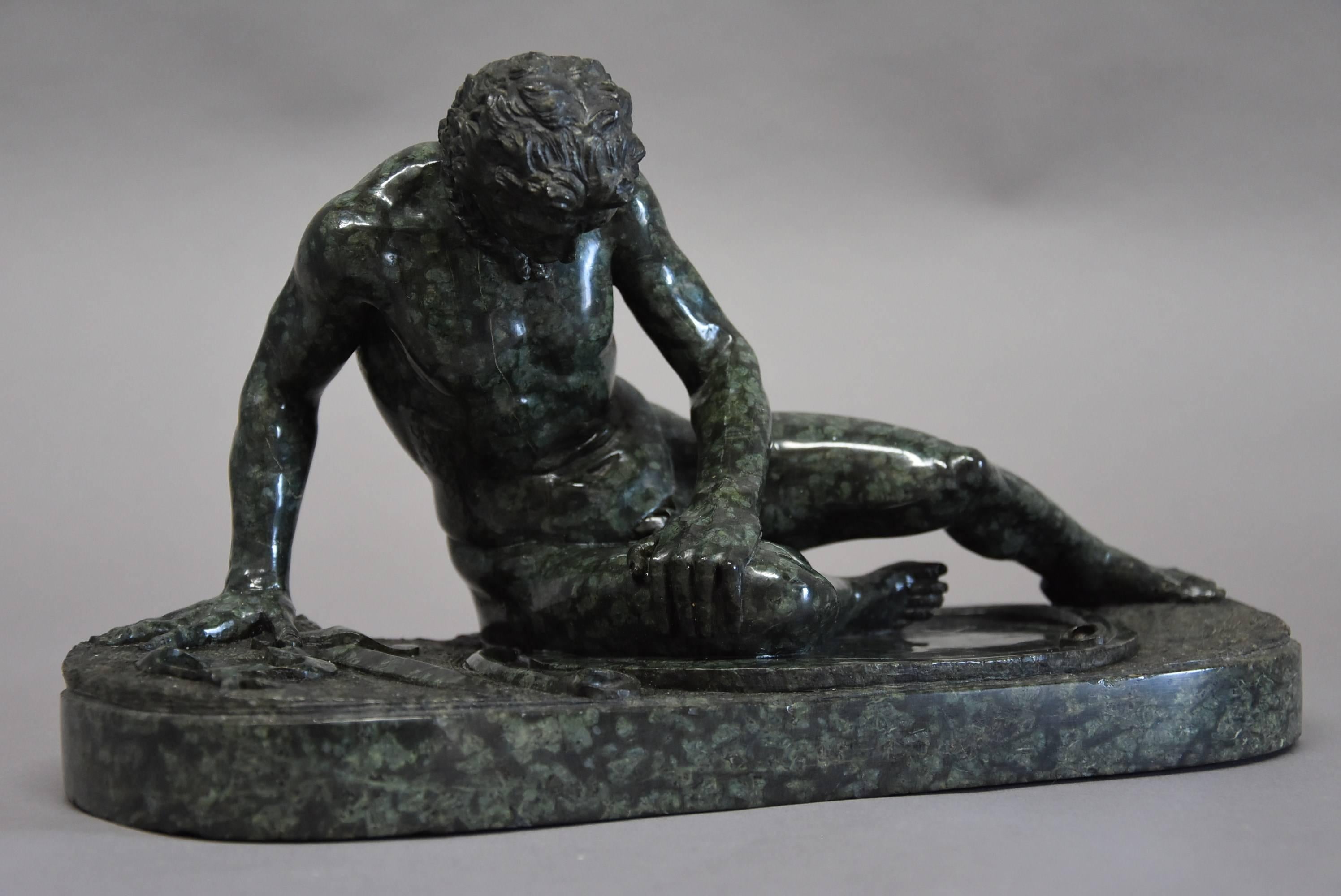 A late 19th century finely carved Grand Tour Italian serpentine figure of 'The Dying Gaul' on integral oval base, after the antique.

The Dying Gaul or Dying Gladiator is depicted in his final moments next to his shield and sword, his face in pain