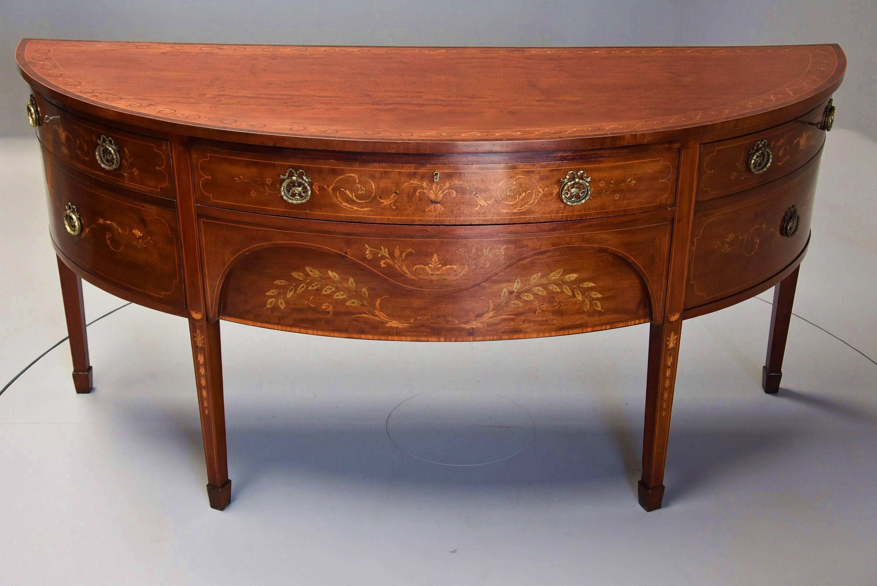 A fine quality and highly decorative Edwardian mahogany bow front sideboard with inlaid decoration by Druce & Co, London in the Sheraton style.

This sideboard consists of a mahogany  top, the central section of finely figured mahogany veneer