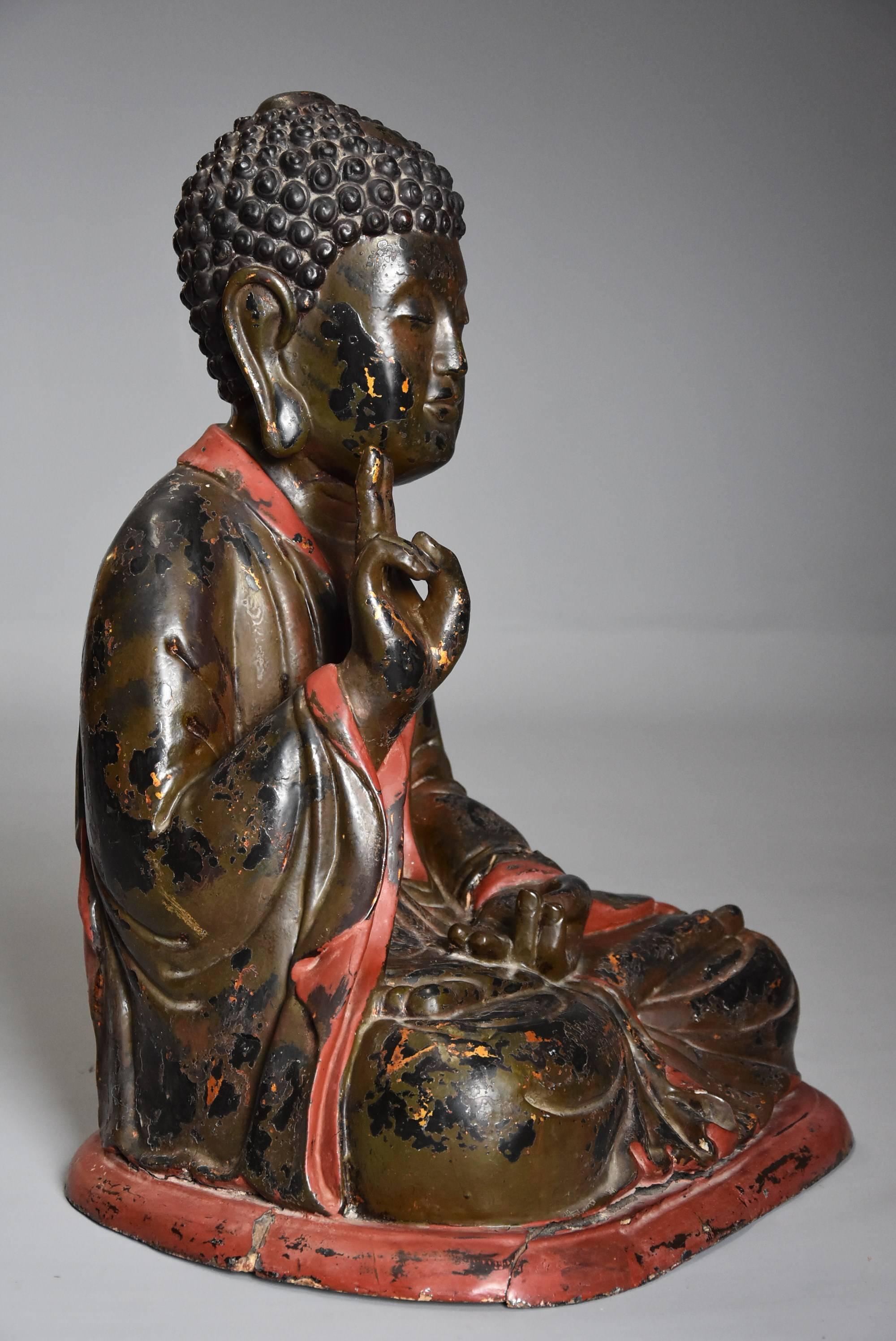 A highly decorative 19th century Vietnamese carved wooden and polychrome painted Buddha with traces of original gilding.

This carved wood polychrome Buddha is seated with his right hand raised and left hand resting with a reverse swastika carved on