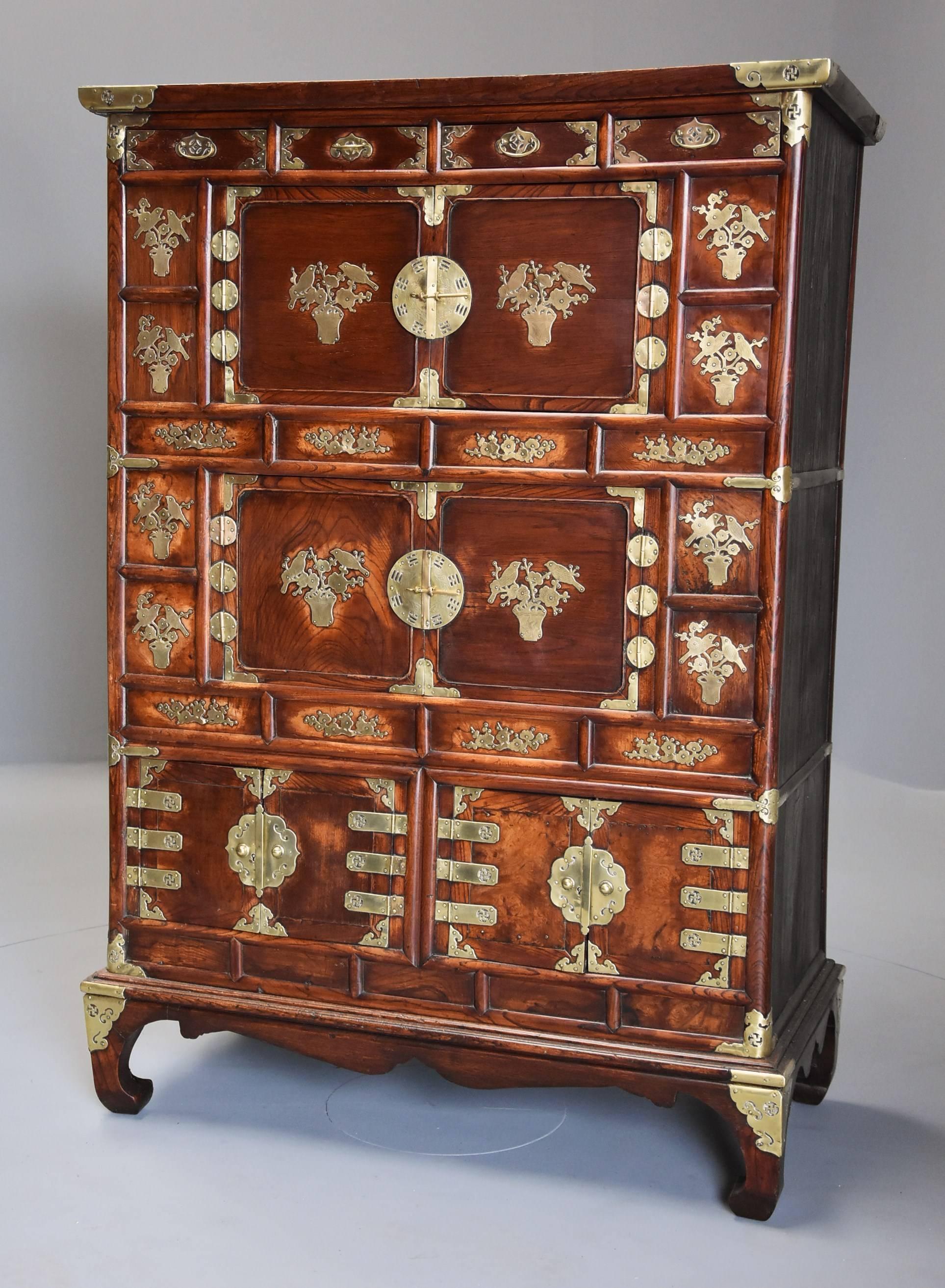 A highly decorative 19th century Korean elm cabinet with brass decoration and of superb patina (color). 

The cabinet consists of an arrangement of various drawers, cupboards and recessed panels, the cabinet having an elm top with moulded