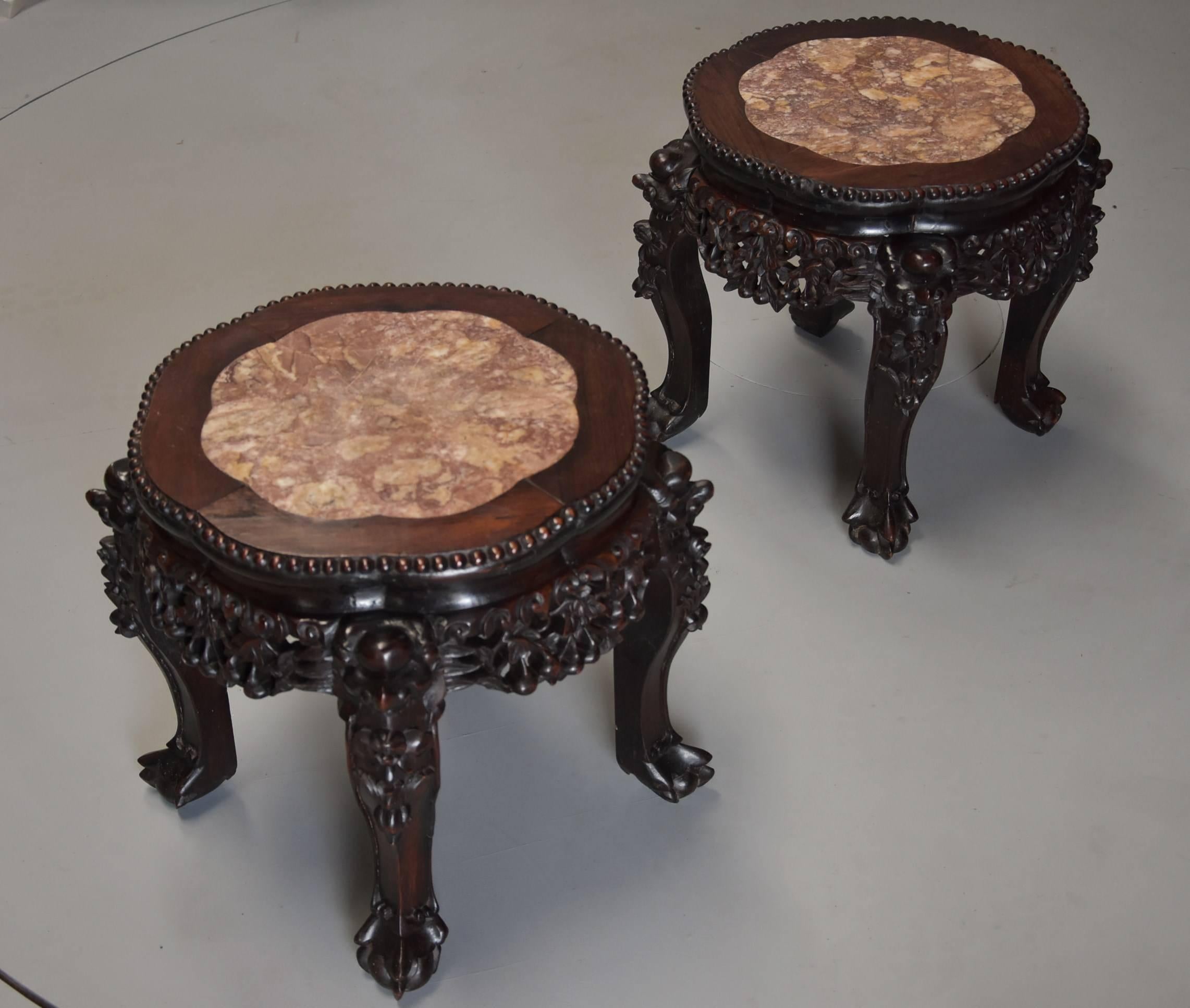 A pair of late 19th century, Chinese hardwood circular pot stands or low tables with marble inset top. 

This pair of stands consist of shaped Chinese rouge marble tops, these being recessed into the top surrounded by ball bead carving.
 
This