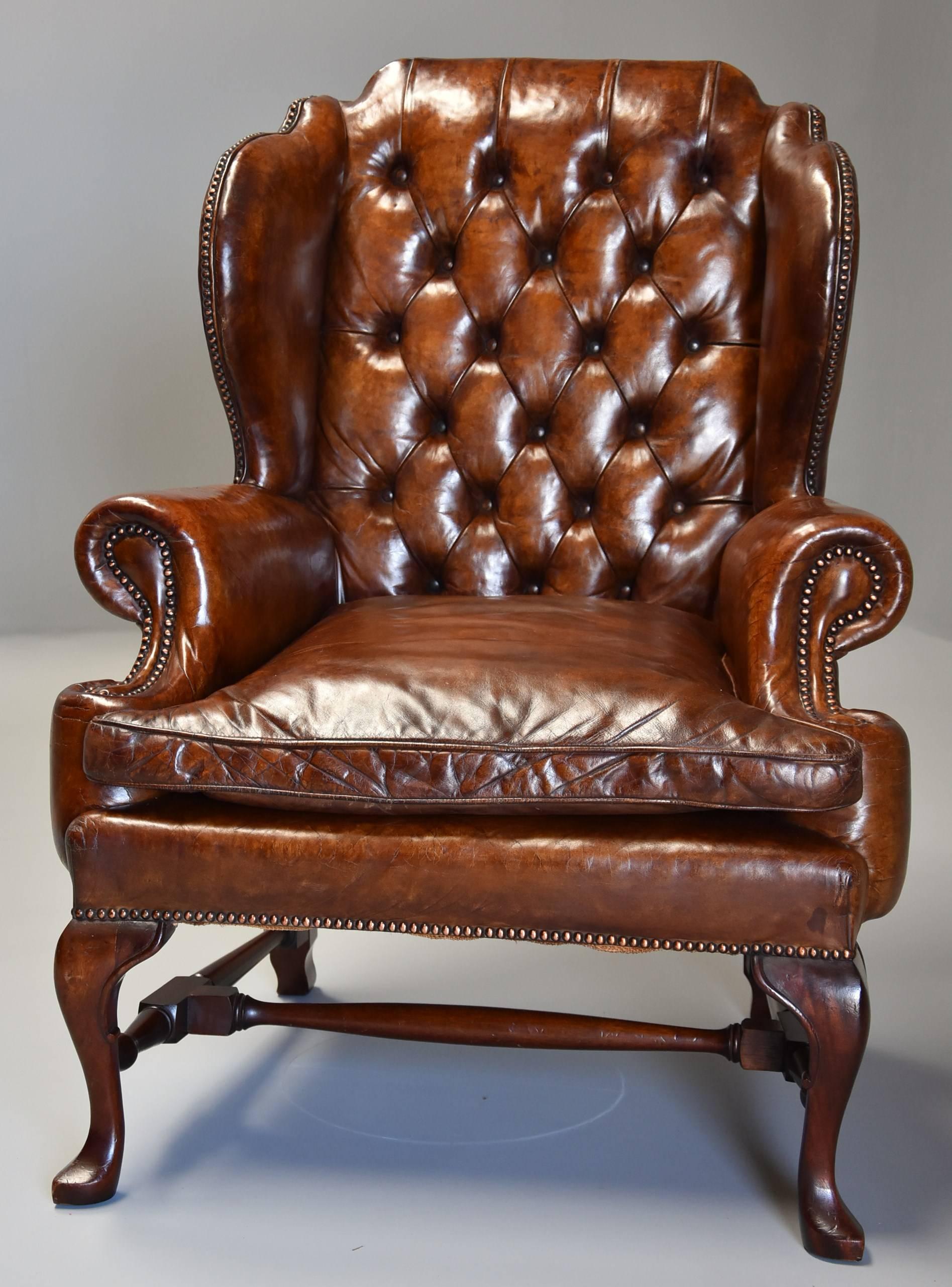 Early 20th century Georgian style deep buttoned brown leather wing armchair.

This superb chair consists of a deep buttoned back with 'wings' to the top with a leather loose seat cushion, the chair retaining original hand dyed brown leather in