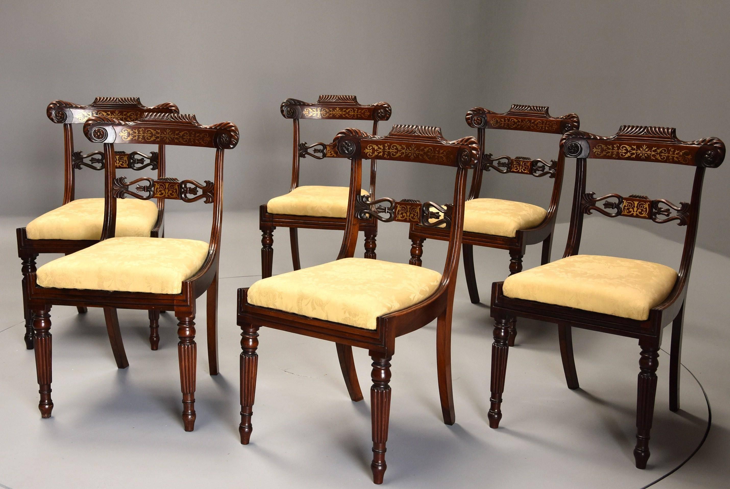 A fine quality early 19th century set of six Regency rosewood dining chairs with brass inlaid decoration.

Each chair consists of a shaped back rail with gadroon carved decoration with carved rosettes to each end with Fine quality inlaid brass