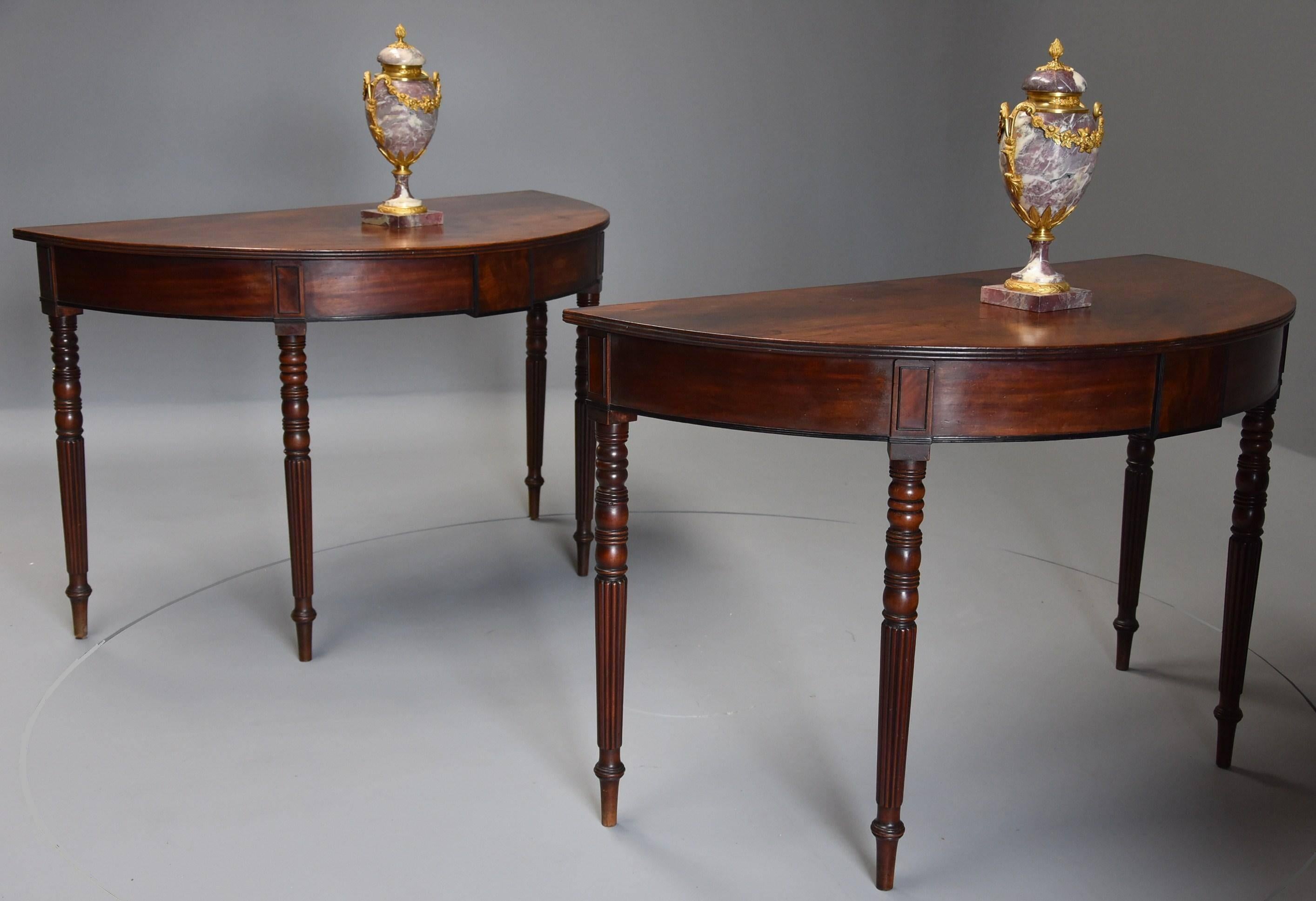 A pair of good quality early 19th century mahogany demi-lune console tables with superb original patina (color).

This pair of tables consist of solid mahogany tops with superb patina with a reeded front edge leading down to a well figured
