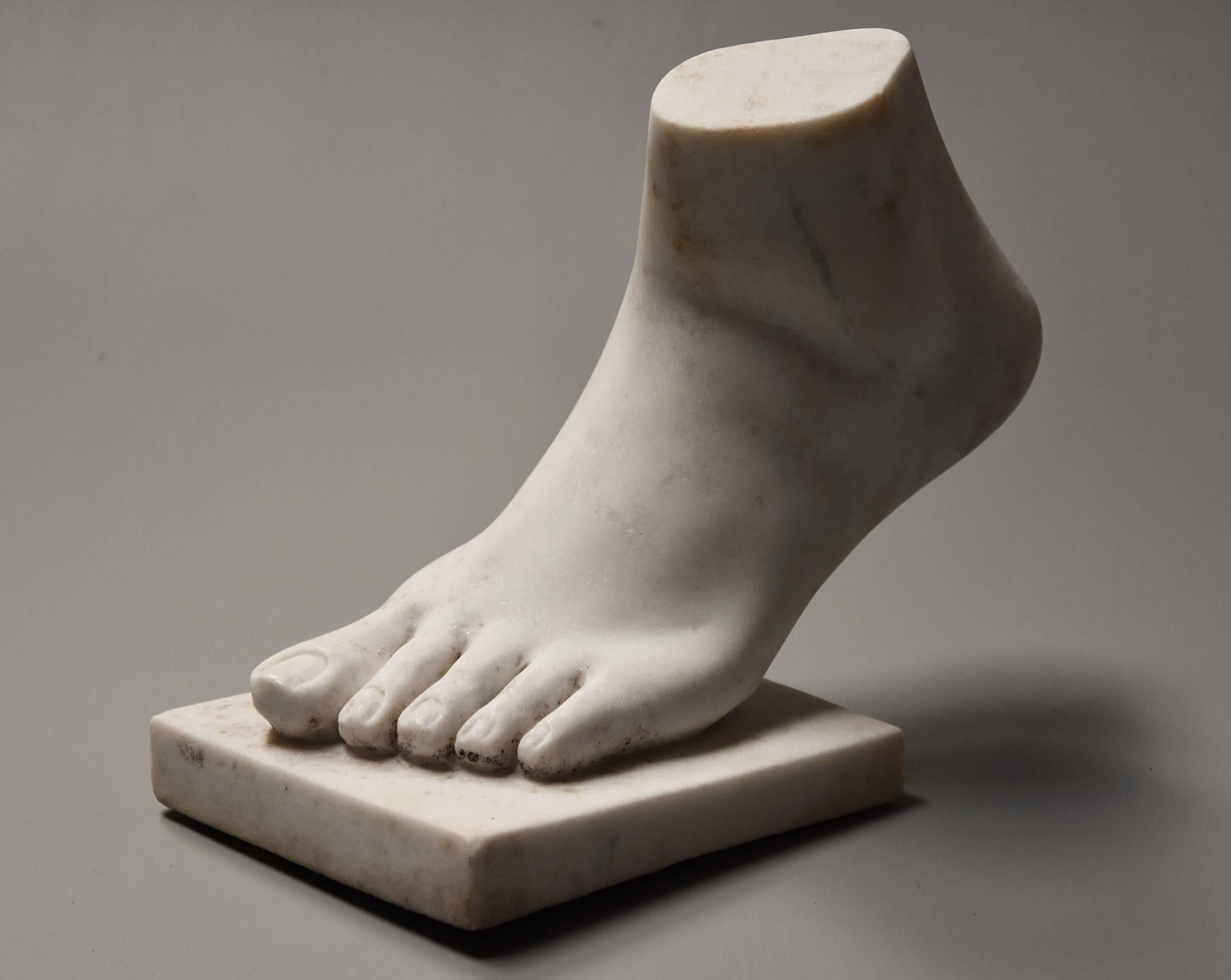 A late 19th century Italian Grand Tour style carved Carrara marble sculpture of a foot supported on a plinth, after the antique.

This marble carving of a foot is in very good condition for age and would make an interesting an decorative addition