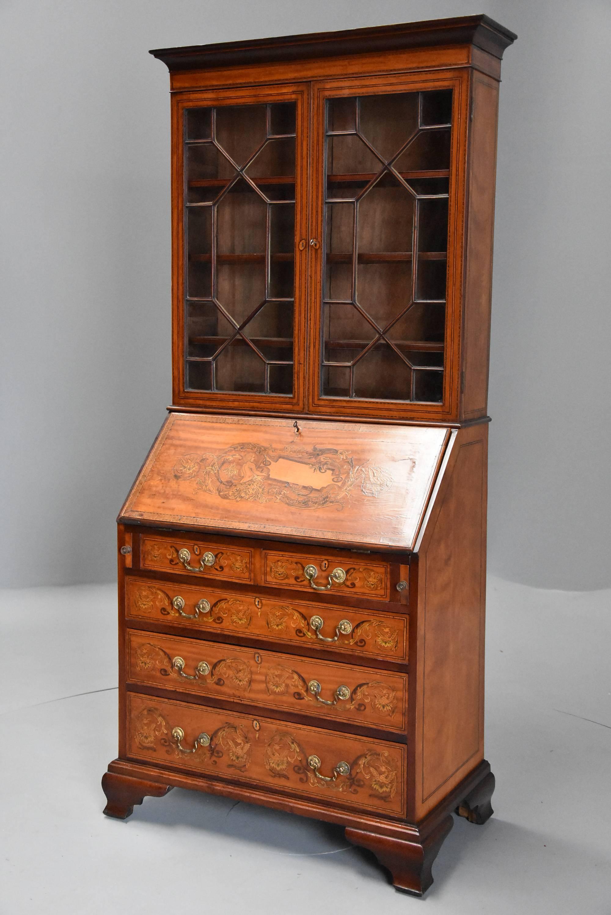An unusual late 19th-early 20th century satinwood, mahogany and marquetry inlaid bureau bookcase of small proportions.

The top section consists of a satinwood and mahogany moulded cornice leading down to a satinwood frieze with boxwood and ebony