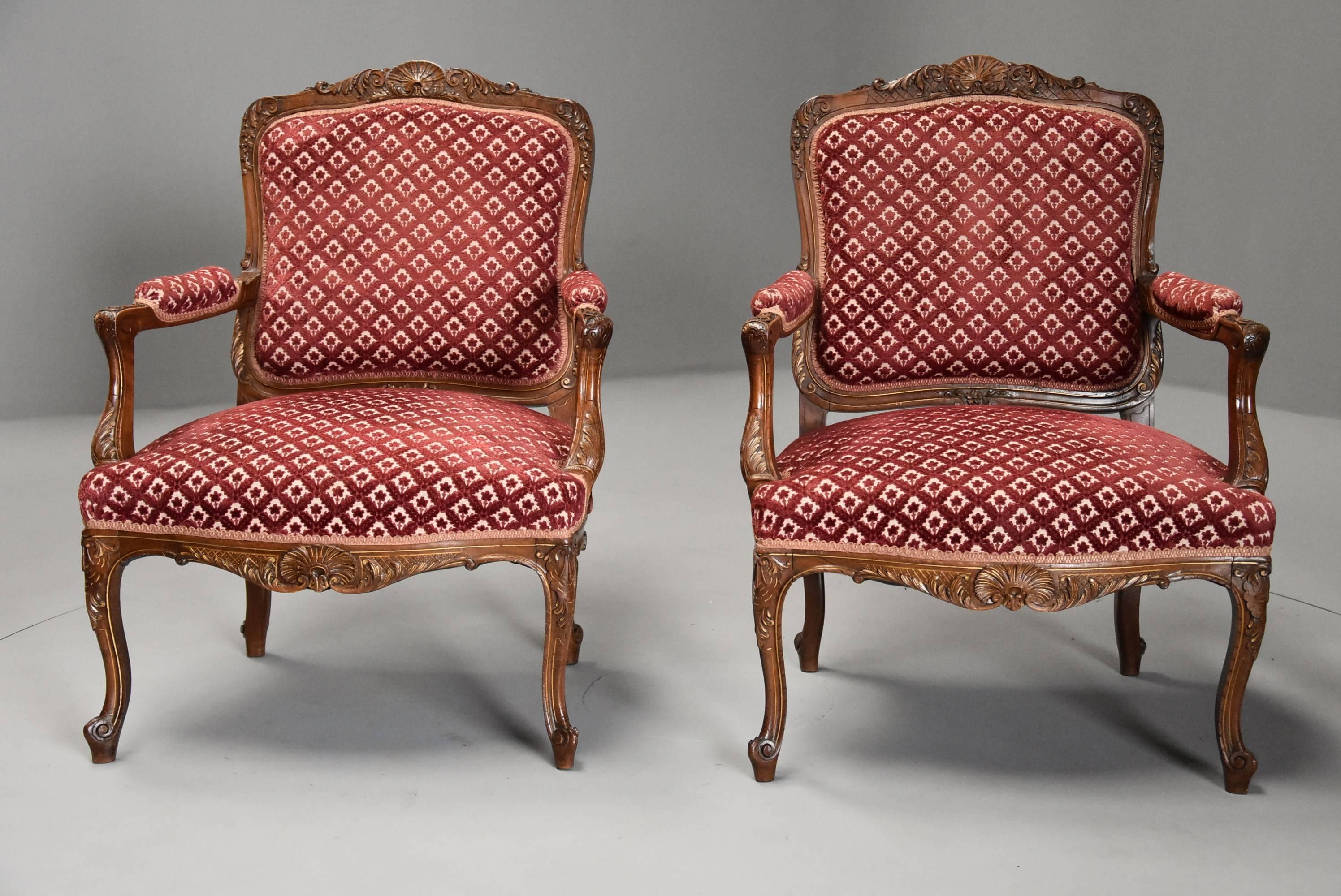 A late 19th century pair of French walnut fauteuils (open armchairs) in the Louis XV style with traces of orignal gilt.

This pair of chairs consist of a cartouche-shaped padded and upholstered back with carved central scallop shell decoration to
