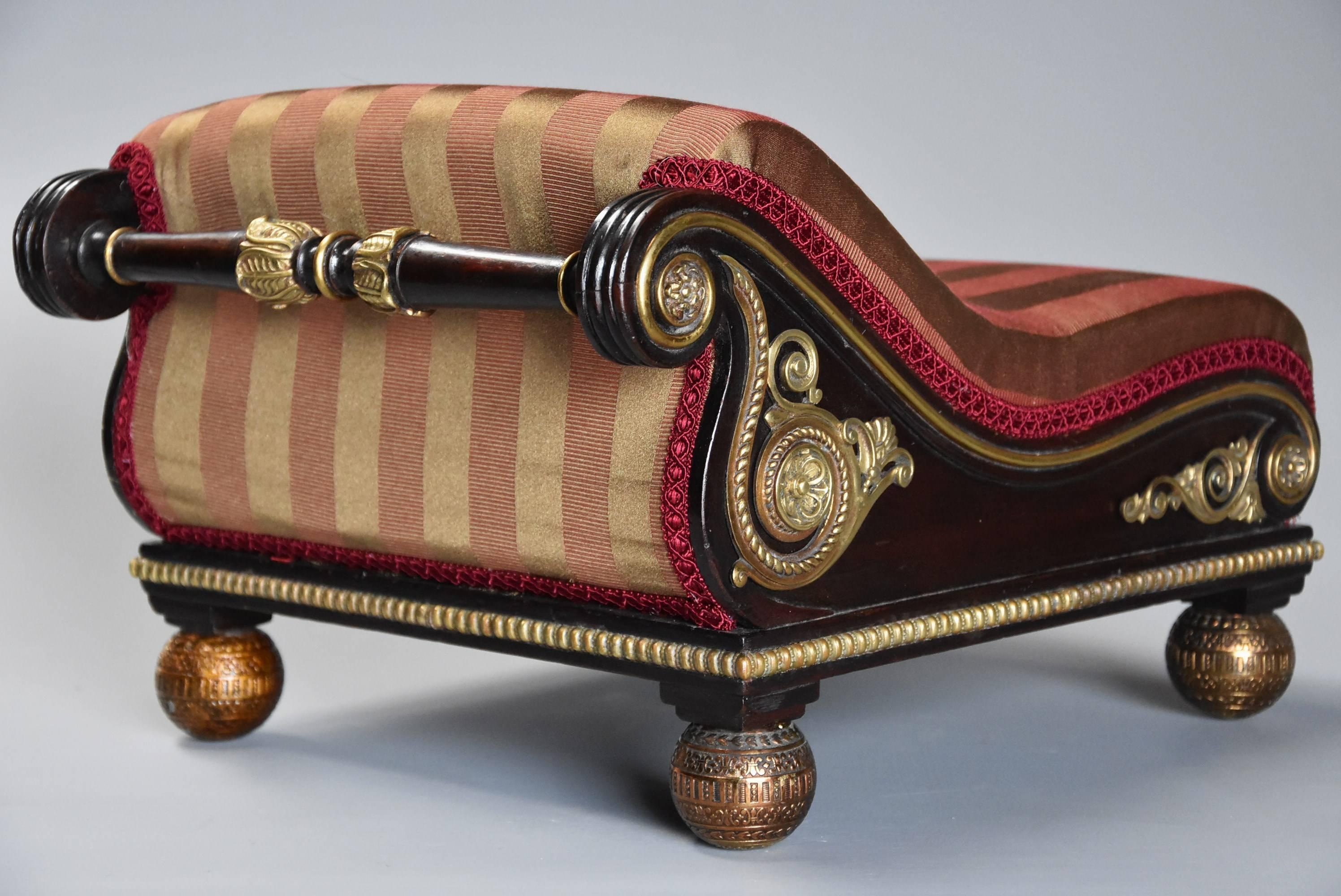 Superb and extremely rare 'design book' example of an early 19th century Regency mahogany scroll top foot stool (or gout stool) with brass mounts in the manner of Matthew Gregson (1749-1824).

This superb shaped stool in the form of a gout stool