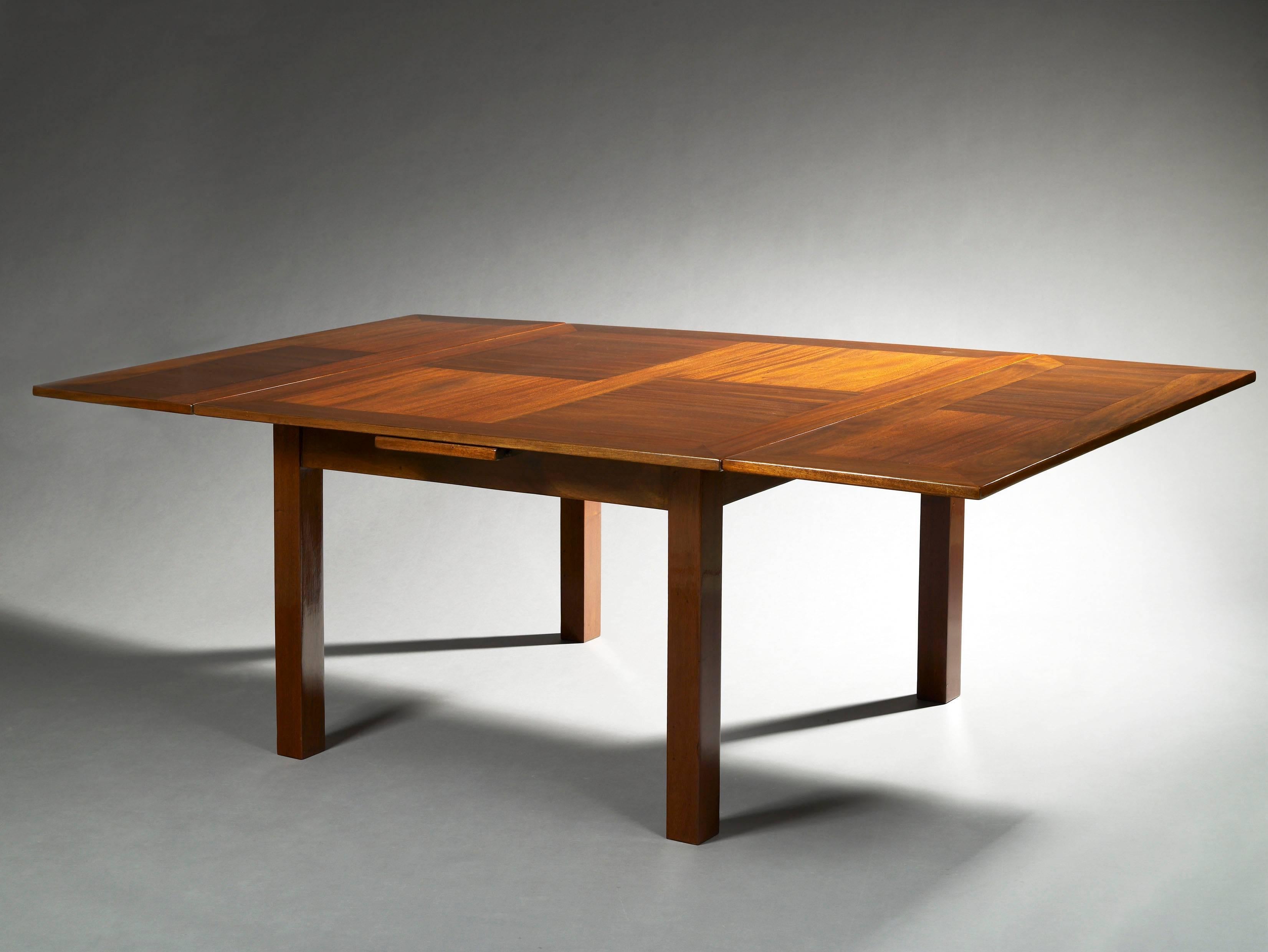 Varnished mahogany dining room table.
Table with a square top with two Italian extensions resting on right square feet. 

This model was edited by the Studium of the Louvre and presented at the salon d'Automne in 1923.