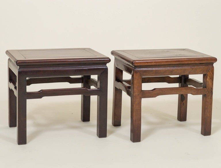 Pair of Chinese rosewood, (Hong Mu), low tables with stretcher legs. Originally taller stools reduced in height to a taboret form. Deep color with contrasting lighter areas have a deep walnut like look. 
Excellent as cocktail tables. Very useable