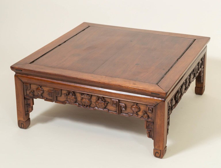 Chinese rosewood, 'Hong Mu', centre table or cocktail table. Originally a taller centre table reduced in height for use as a cocktail table. All four aprons and supporting brackets carved in deep relief. Censors, teapots and vases bordered on the