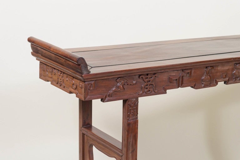 Chinese rosewood, (Hong Mu), altar table. Late Qing dynasty, circa 1900. 
A simple design, with deep relief carved apron, fully surrounded in relief with a Meander border. Beautiful carved censors, vases of flowers, bats and auspicious characters