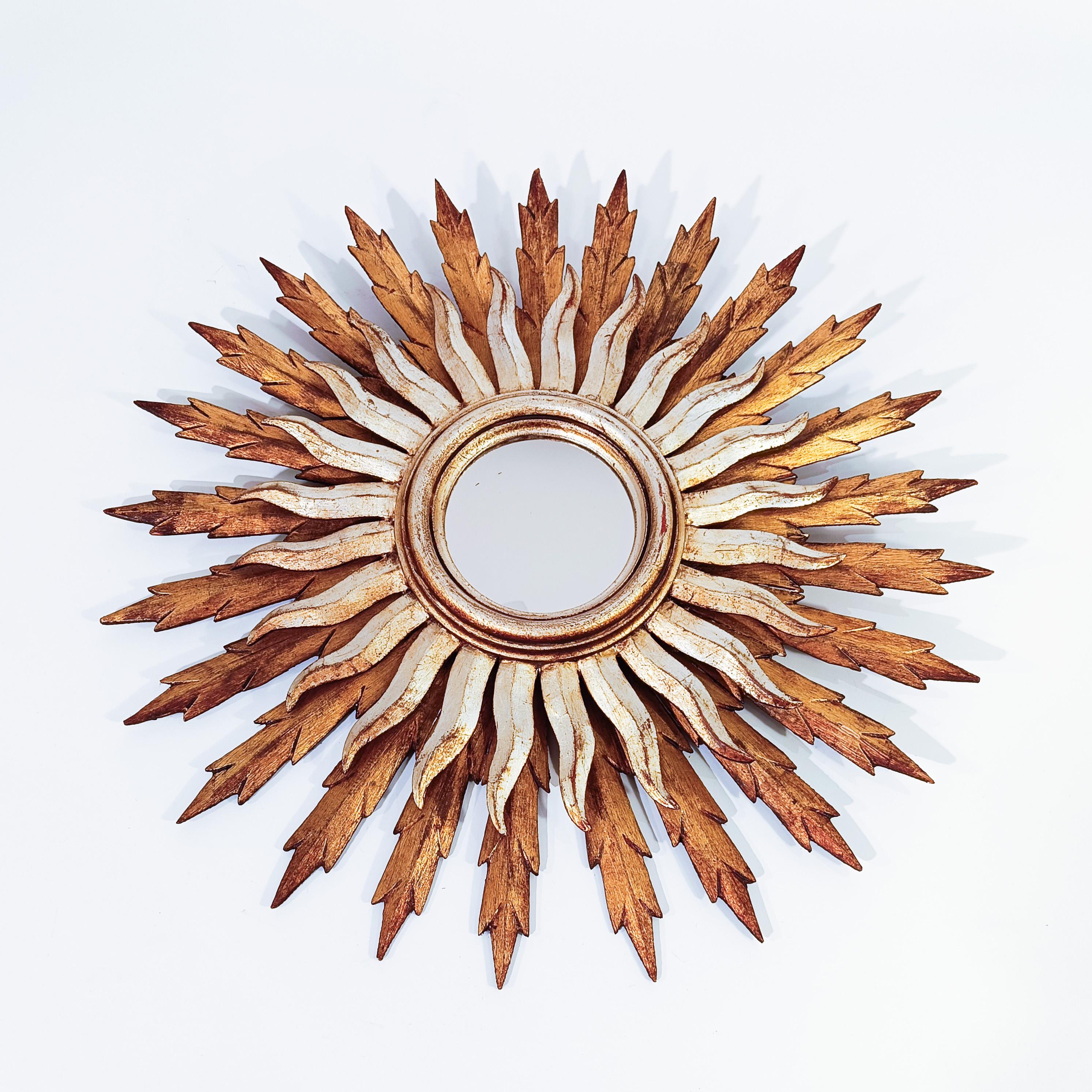 Doppio specchio a raggiera in legno intagliato, Francia, anni 1950. Formata da due corone concentriche di raggi in legno fatti a mano: una grande corona con raggi dorati in foglia d'oro e un'altra corona con raggi argentati in foglia d'argento e di
