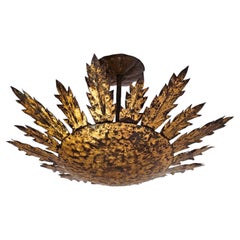 Lámpara de hierro forjado de estilo neotudor con motivos «Sunburst» dorados, de montaje empotrado, de Ferro Art, España, década de 1950