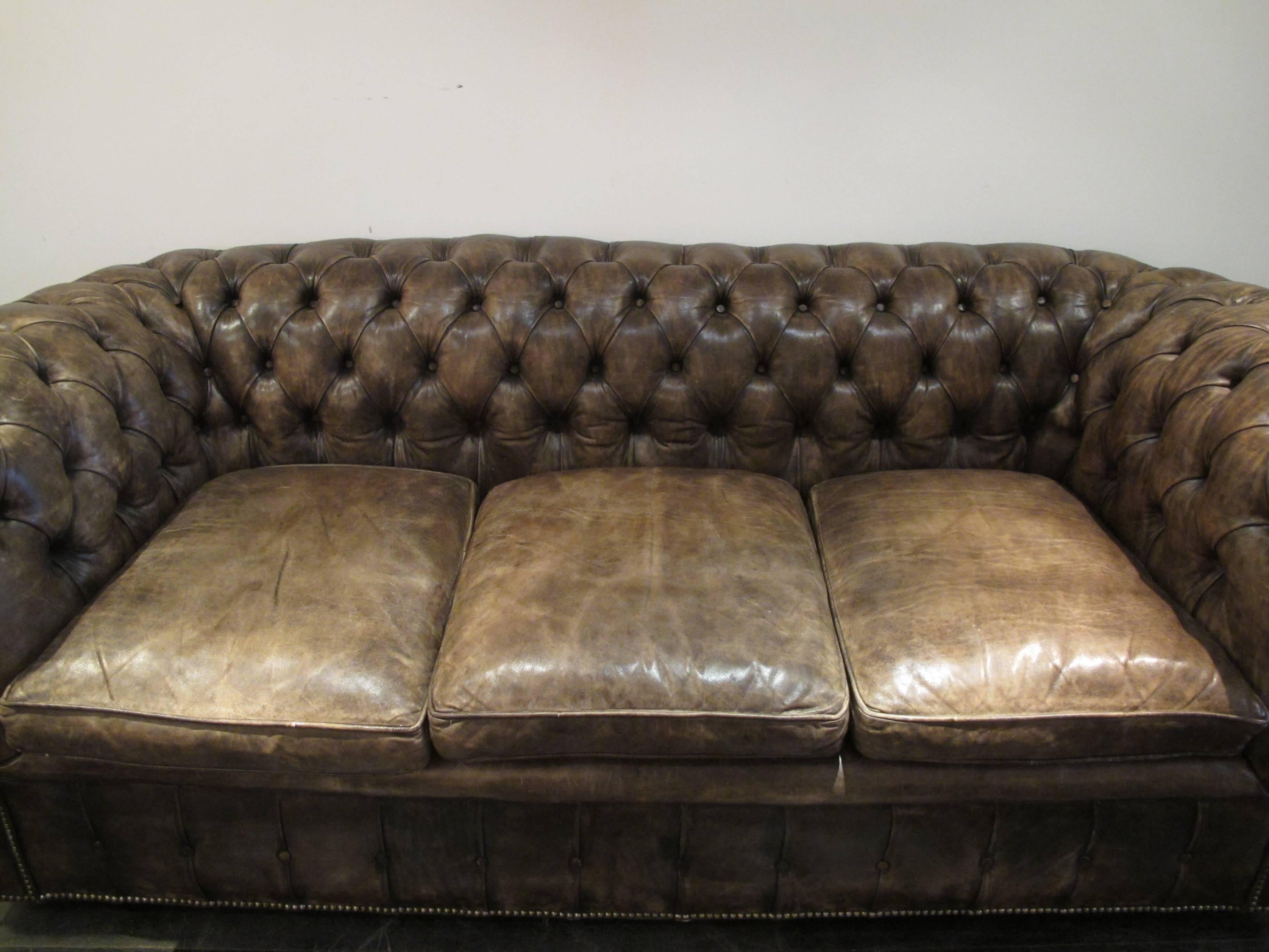 A beautiful aged leather chesterfield, brown faded patina, circa 1950.