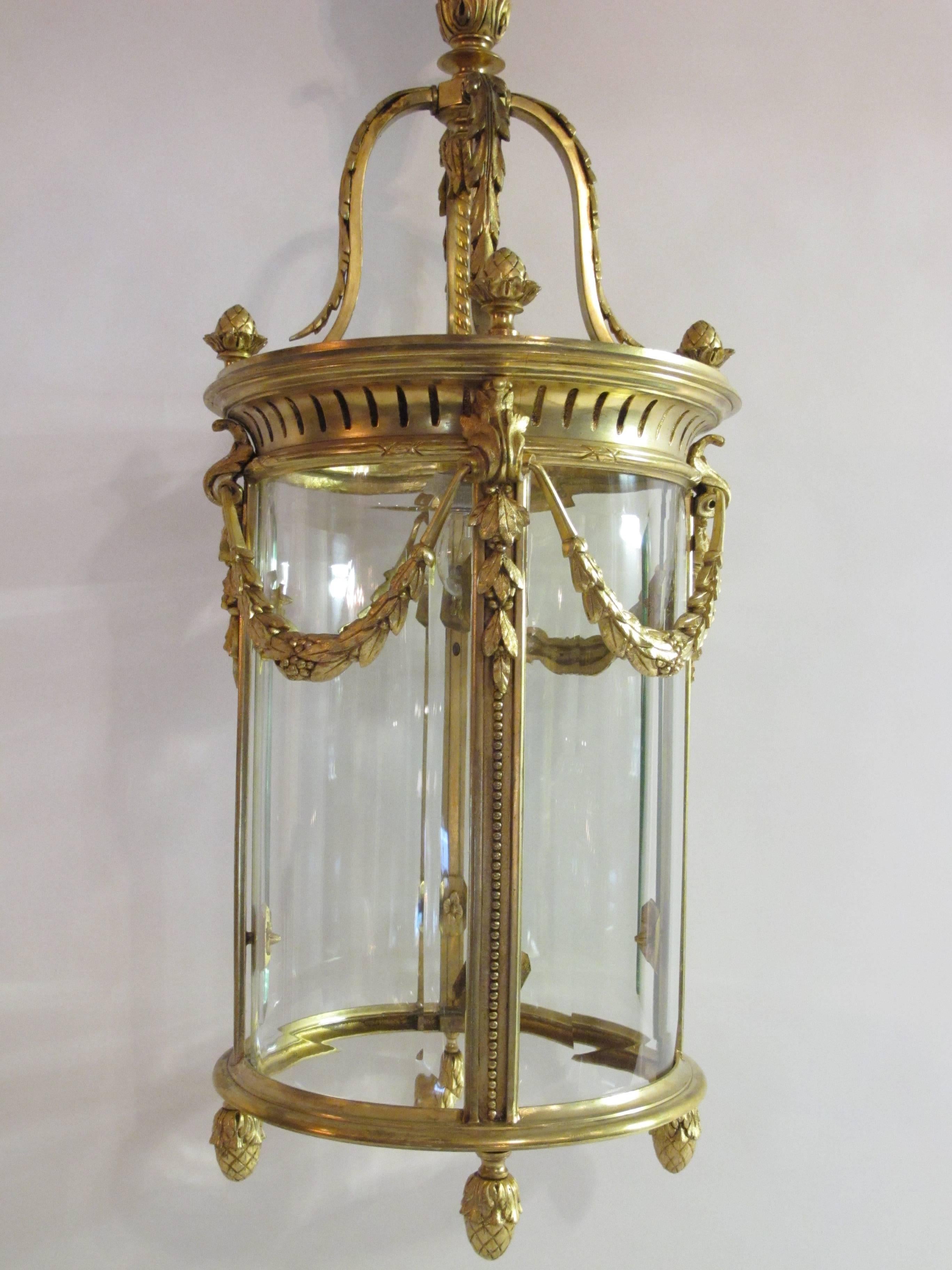 An exquisite French Louis XVI style gilt bronze and glass, one light lantern of Fine detail embellished gilt bronze floral wreaths, with cut-glass, France, circa 1930.