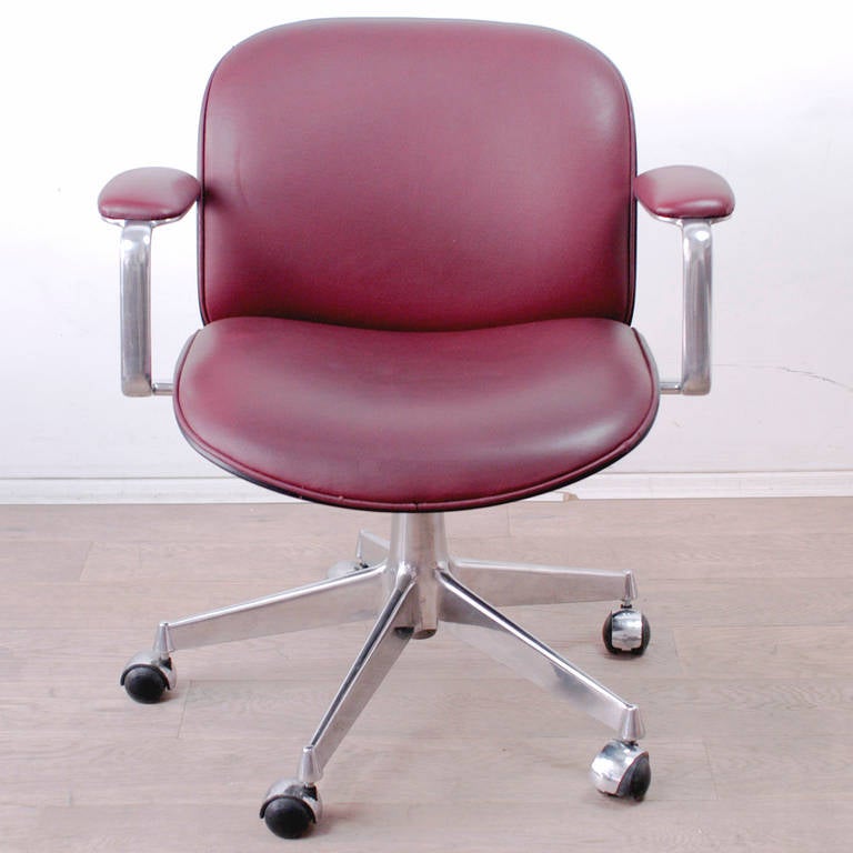 Iconic swivelling office chair by Ico Parisi for MIM Roma with rosewood veneer shell, five star aluminium base on wheels and red skai upholstery
Manufacturers MIM Roma label on the back.